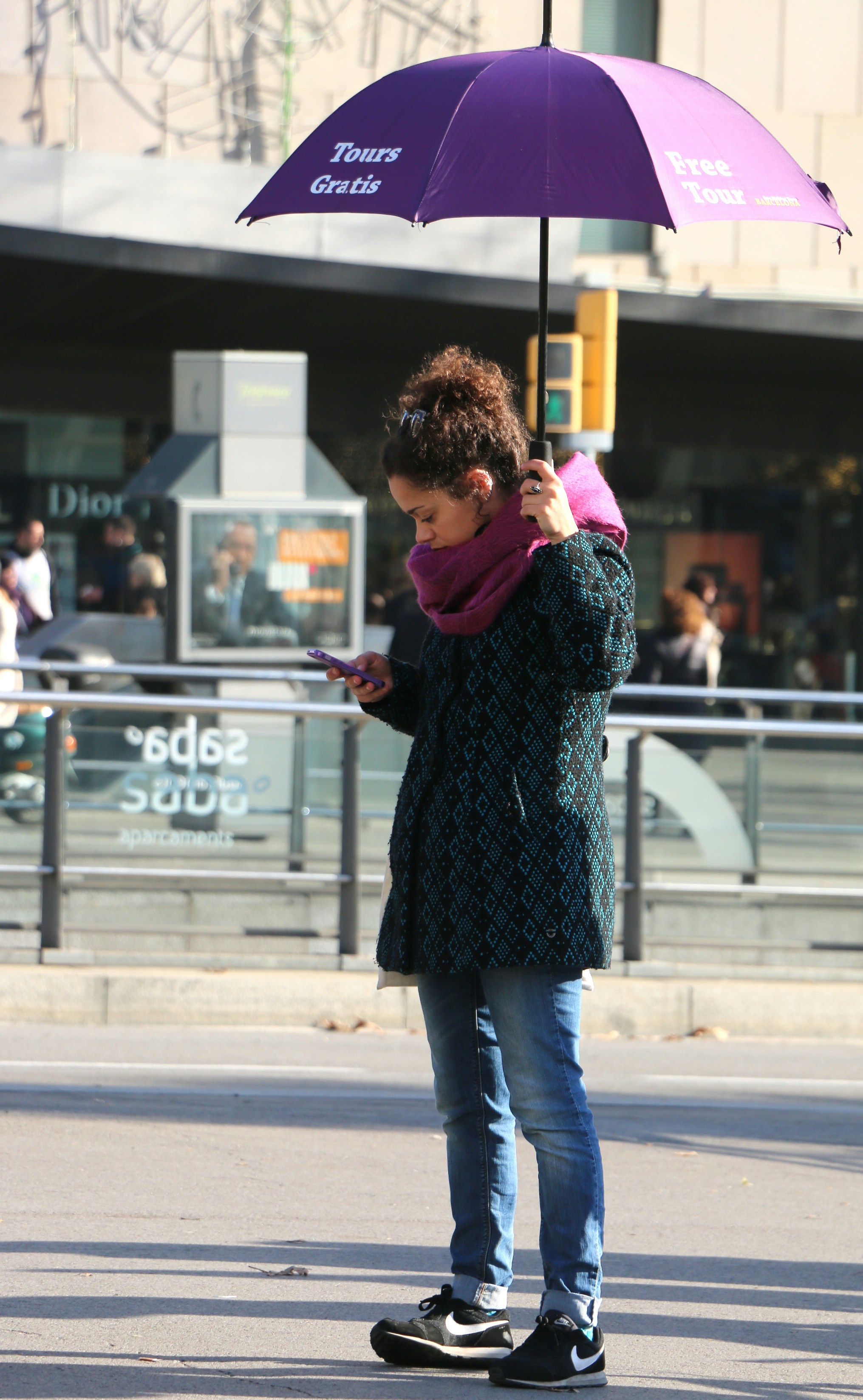Une personne utilisant son smartphone pour consulter rapidement une information tout en marchant dans un environnement urbain moderne.