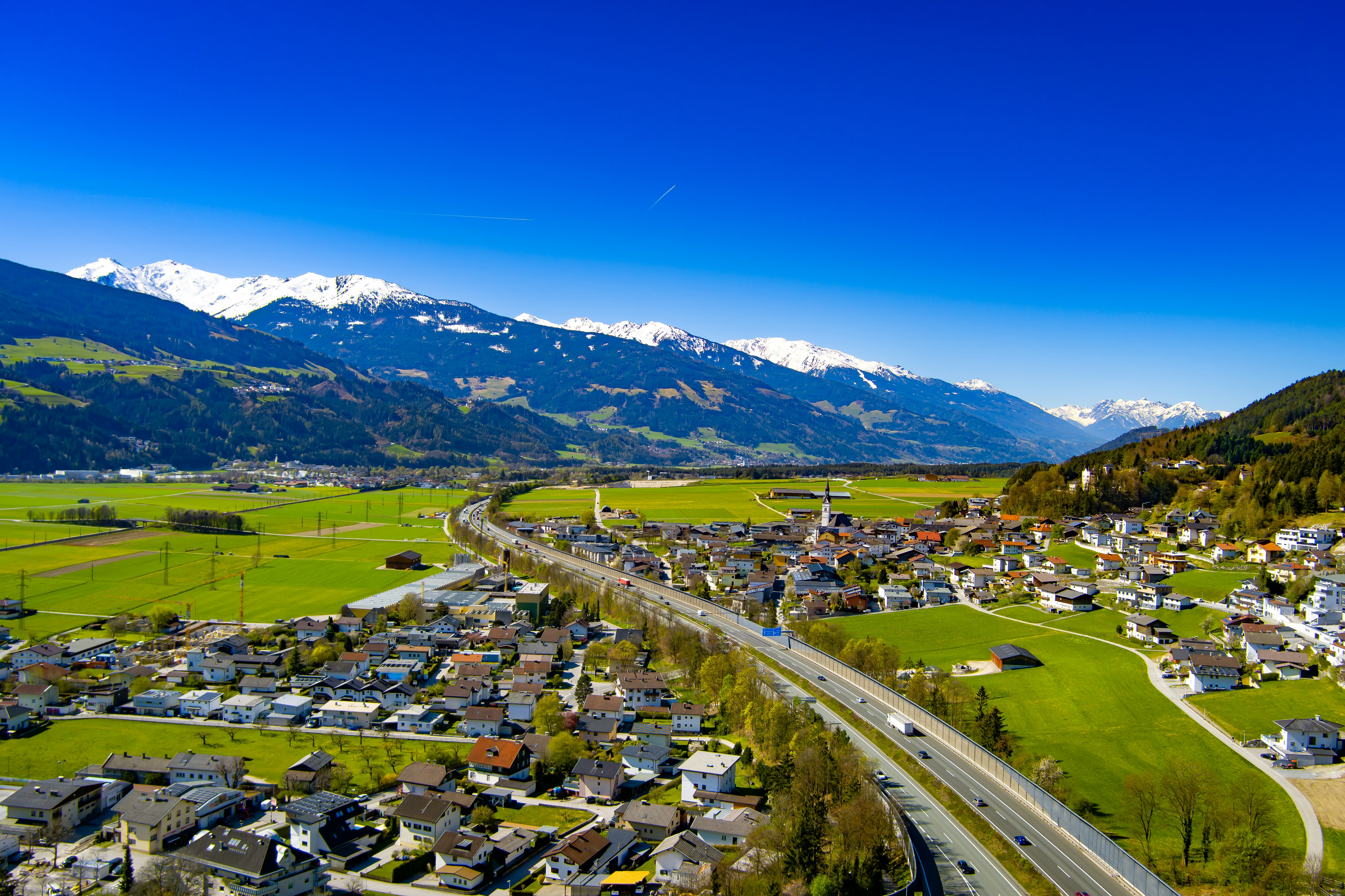 Vue aérienne d'un quartier d'affaires en Suisse, avec des montagnes en arrière-plan, symbolisant la solidité et la perspective que procure une bonne gestion fiduciaire.