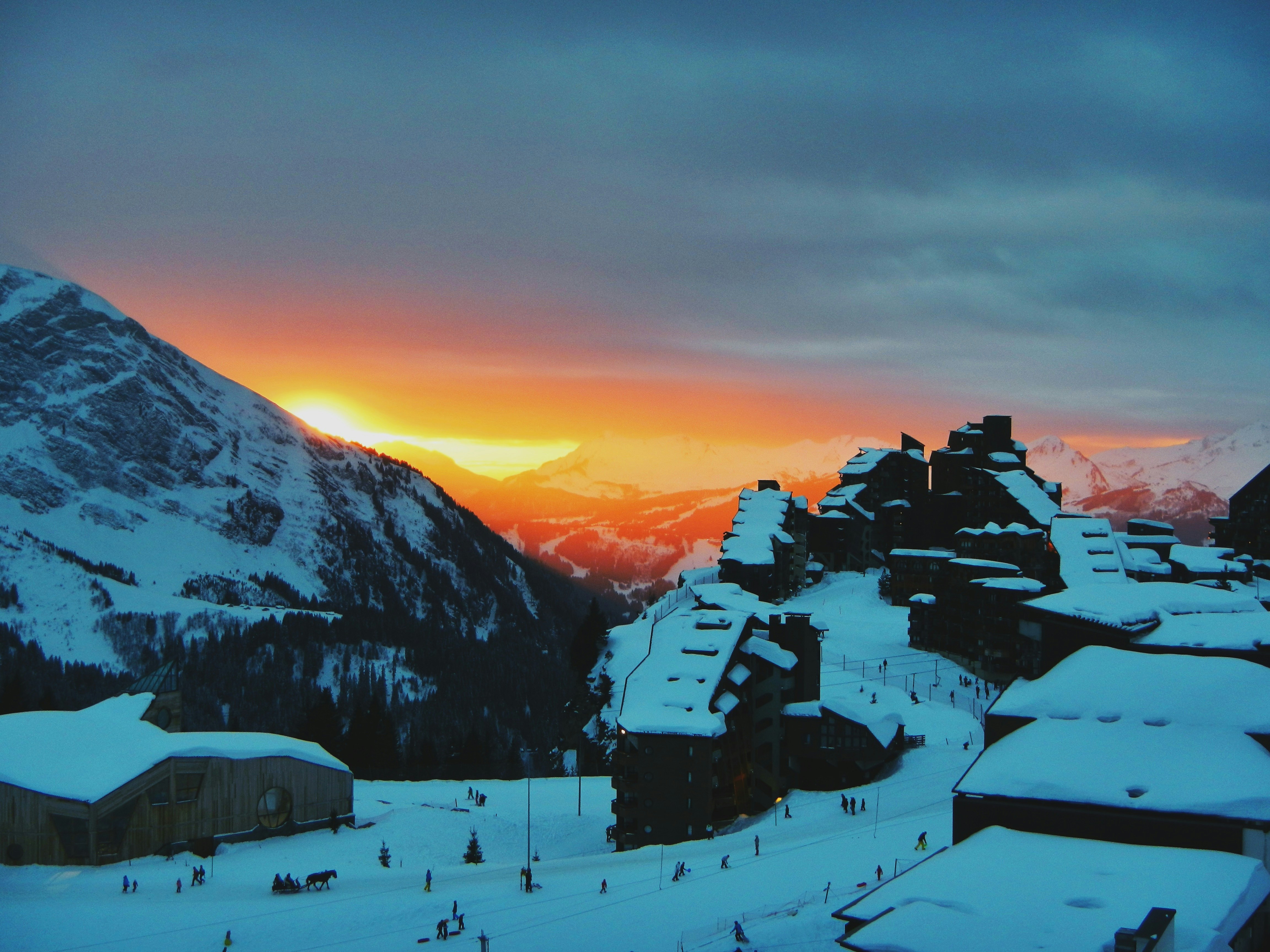 Paysage alpin suisse serein au lever du soleil, avec un lac calme et des montagnes en arrière-plan, parfait comme décor pour une séance photo extérieure.