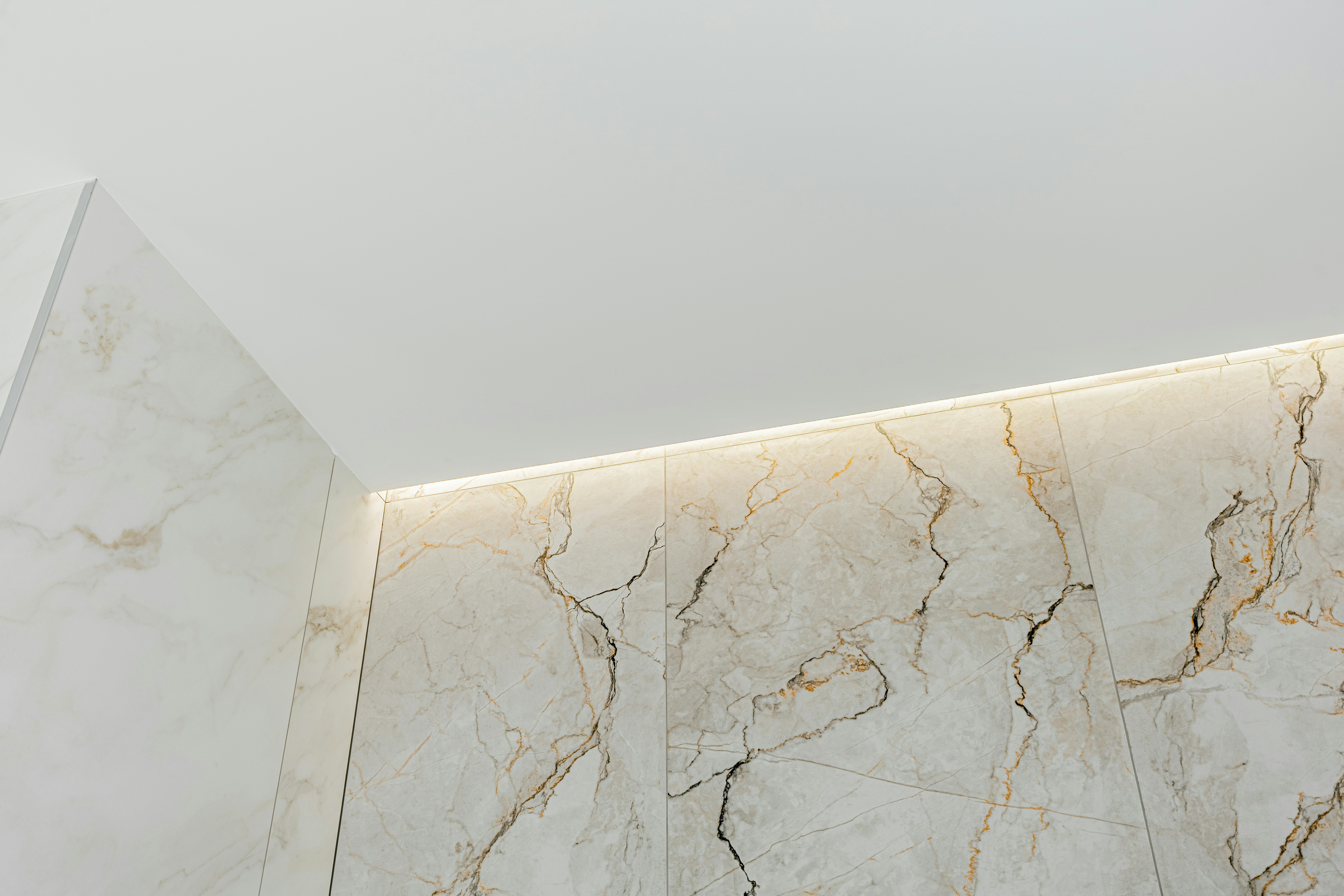 Dans un showroom, un architecte et son client discutent devant un magnifique échantillon de marbre, visiblement inspirés.