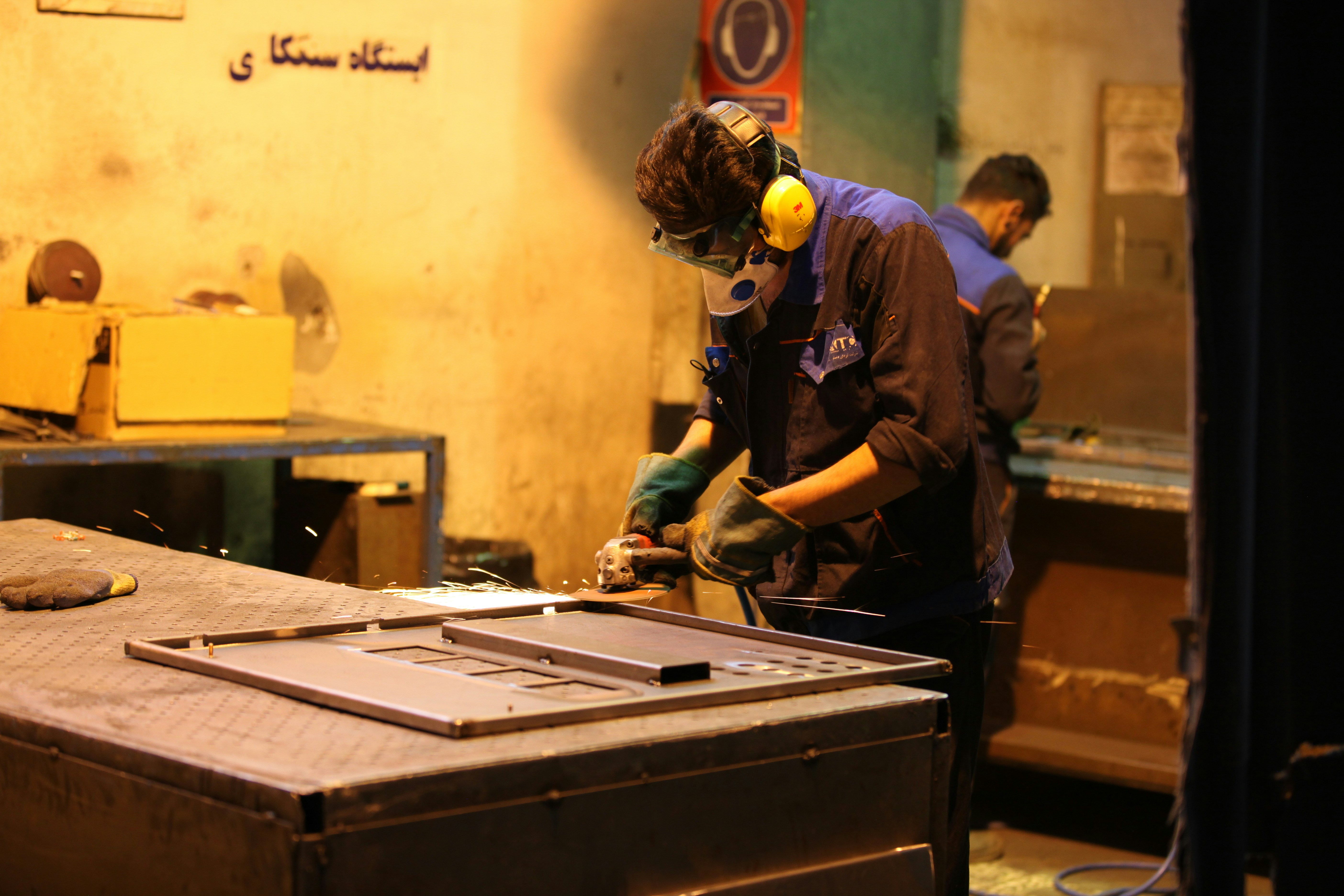 Un soudeur professionnel dans un atelier, créant des étincelles en soudant une pièce métallique sur mesure pour une machine agricole.