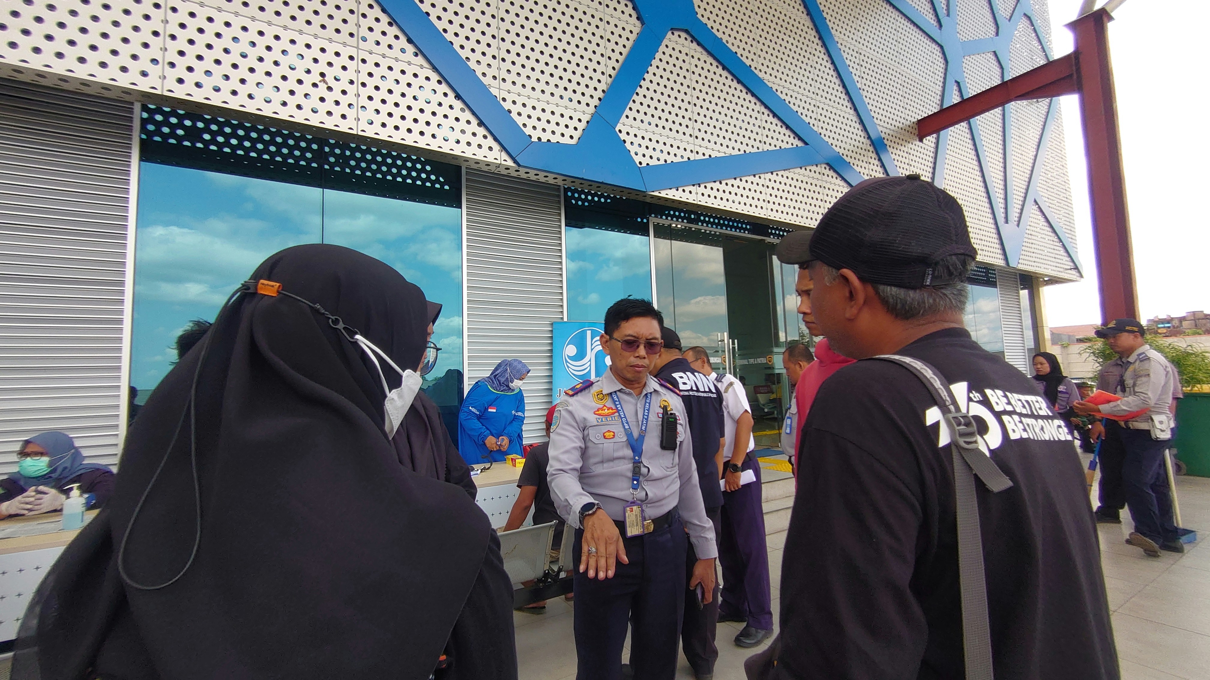 Un gestionnaire souriant et professionnel accueillant chaleureusement un couple de voyageurs à la porte d