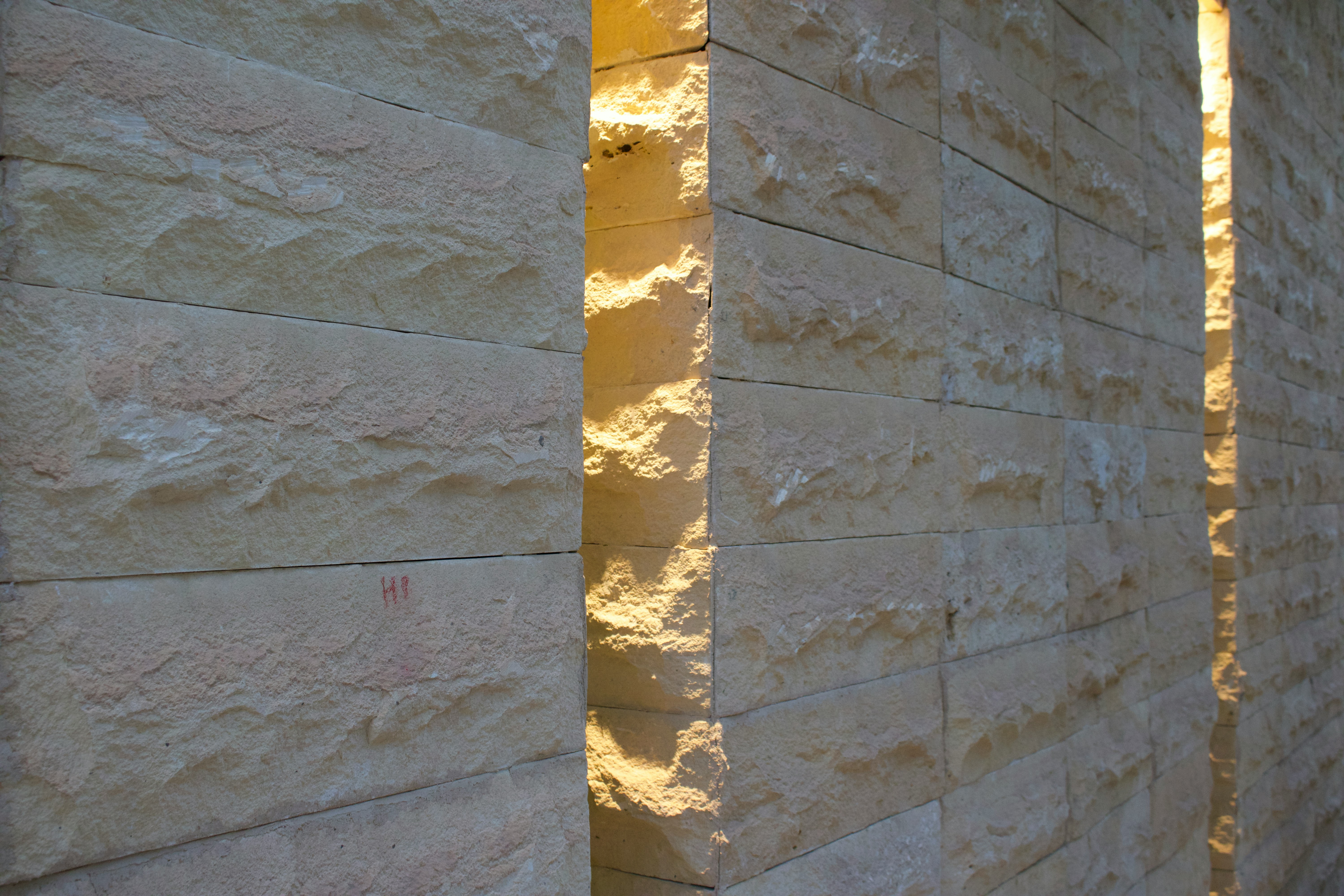 Pavés en pierre naturelle mouillés par la pluie dans une cour, mettant en évidence la texture et les propriétés antidérapantes.