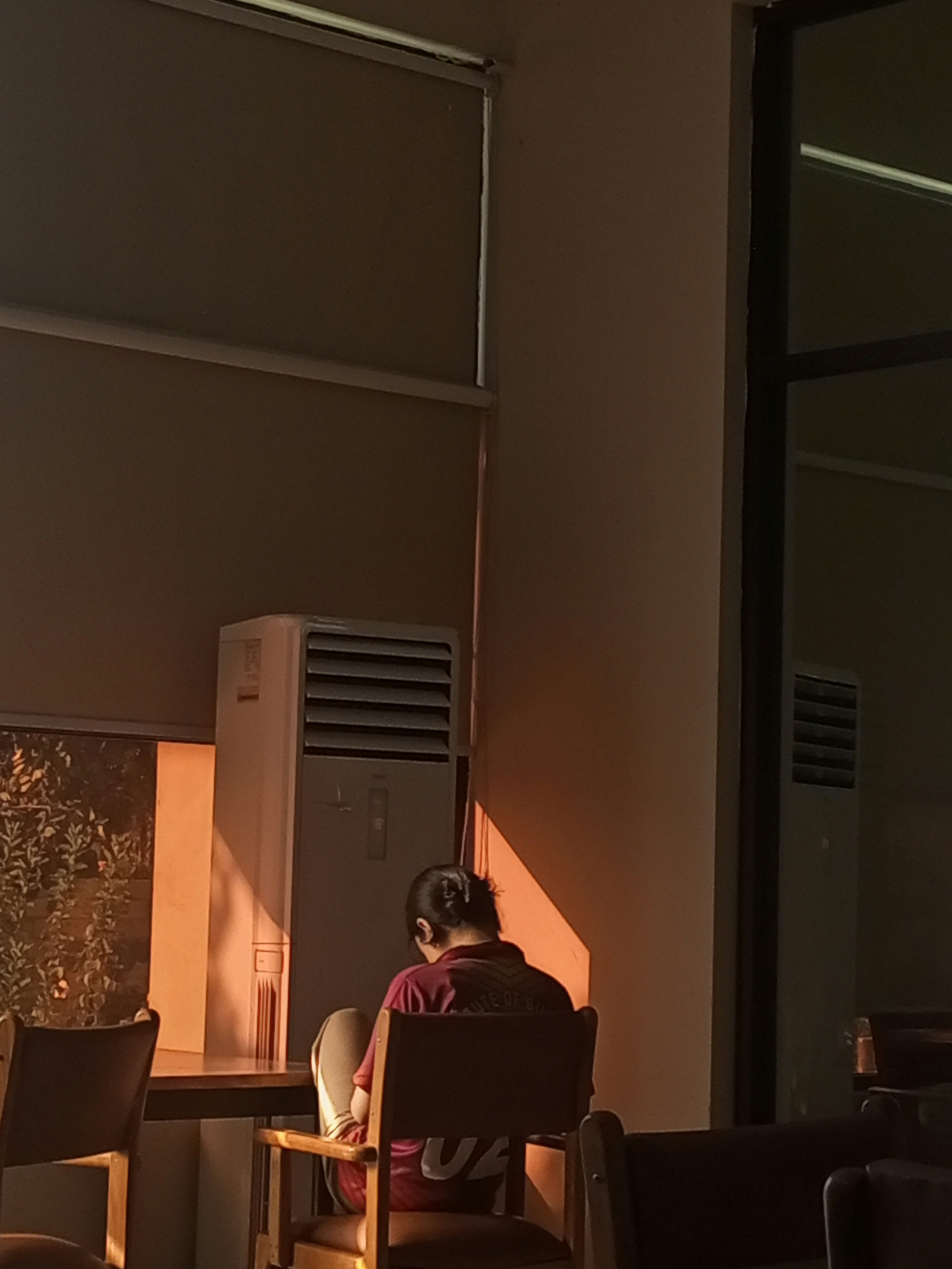 Les mains d'une personne utilisant un mètre ruban pour mesurer avec précision le cadre intérieur d'une fenêtre en bois.