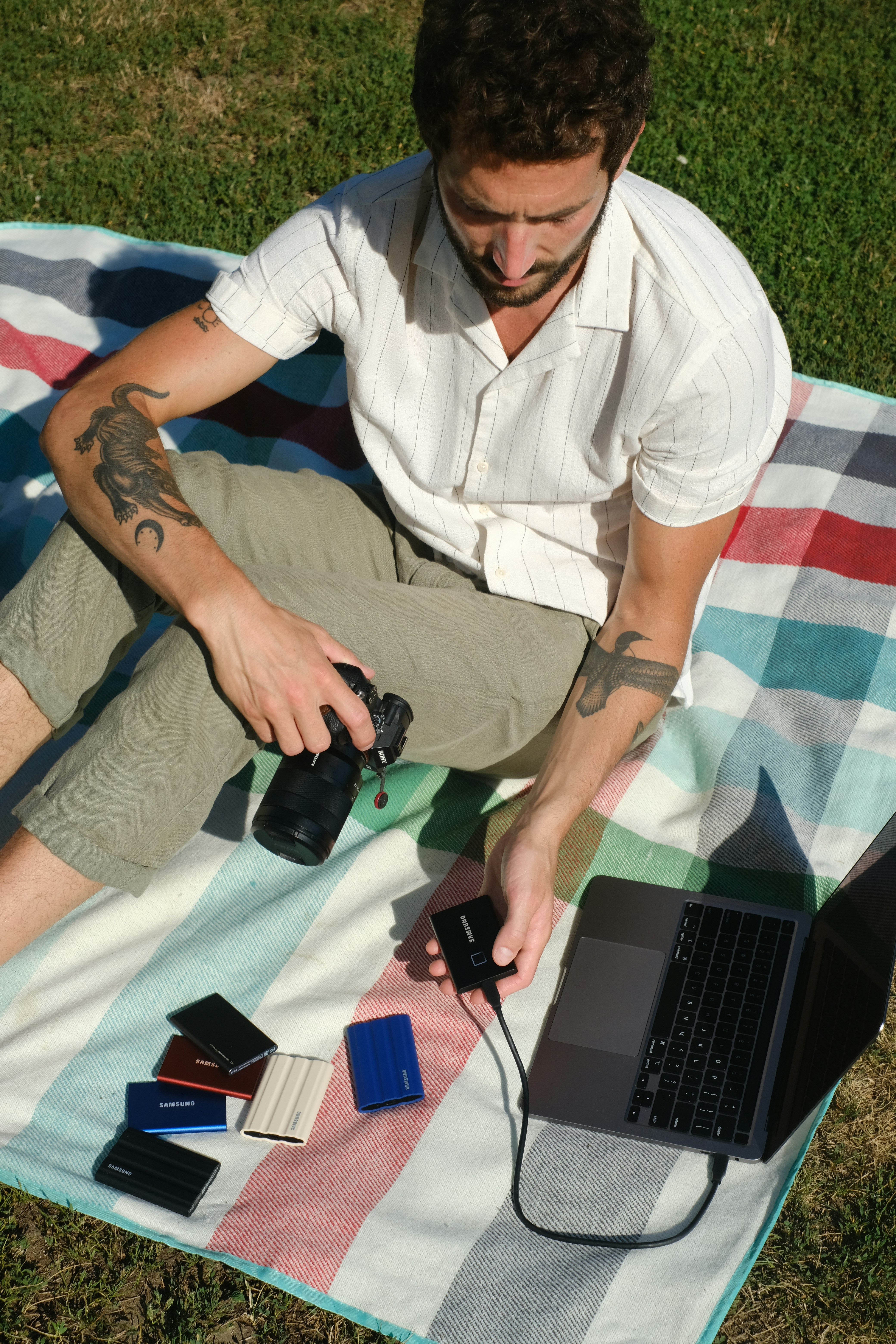 A smiling creative professional working away on a laptop in a bright, modern office.