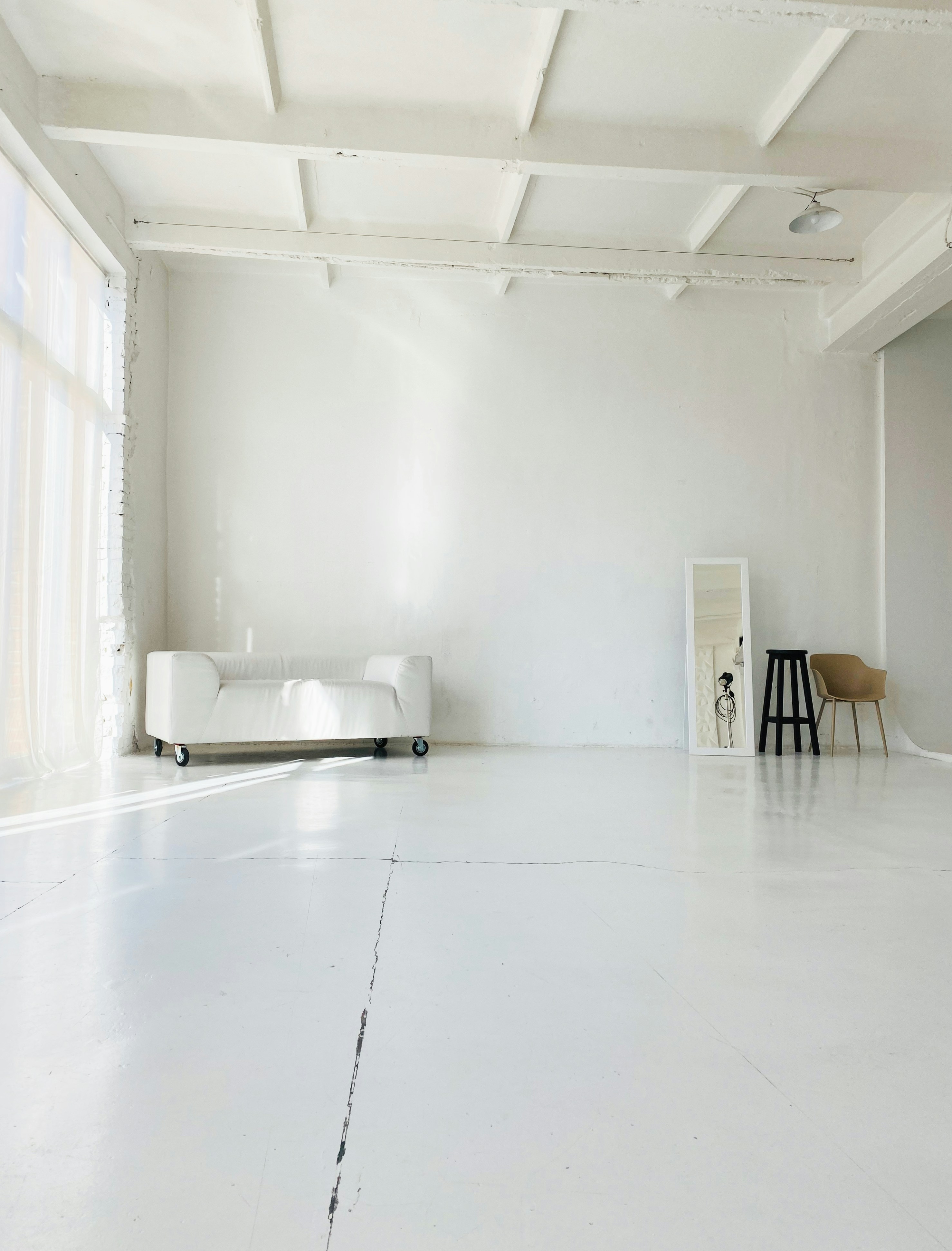 Two ballet dancers work through a routine in a bright, minimalist studio with warm wooden floors.