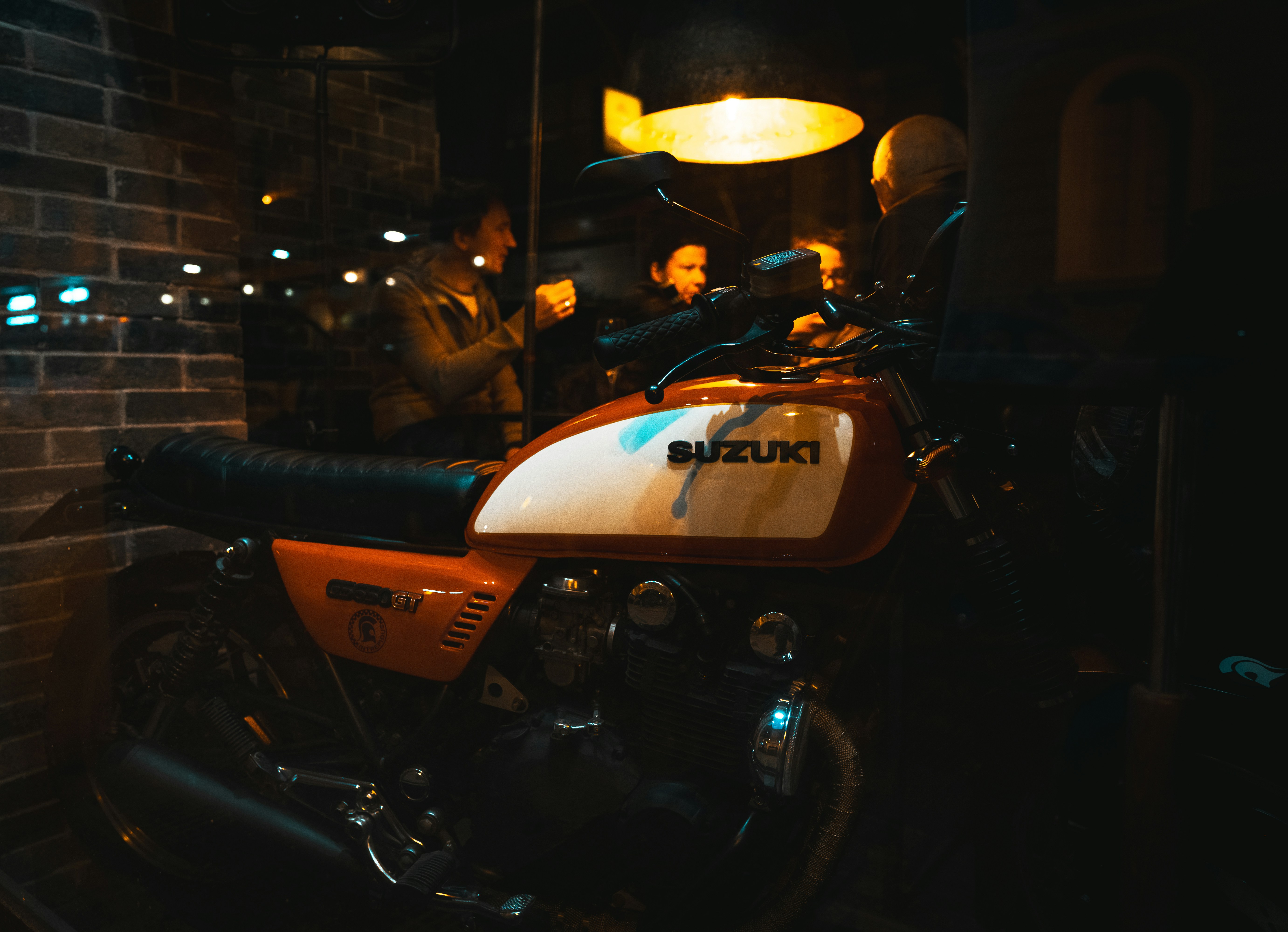 Une moto custom de style chopper garée devant une façade de bar en bois de style Far West au coucher du soleil.