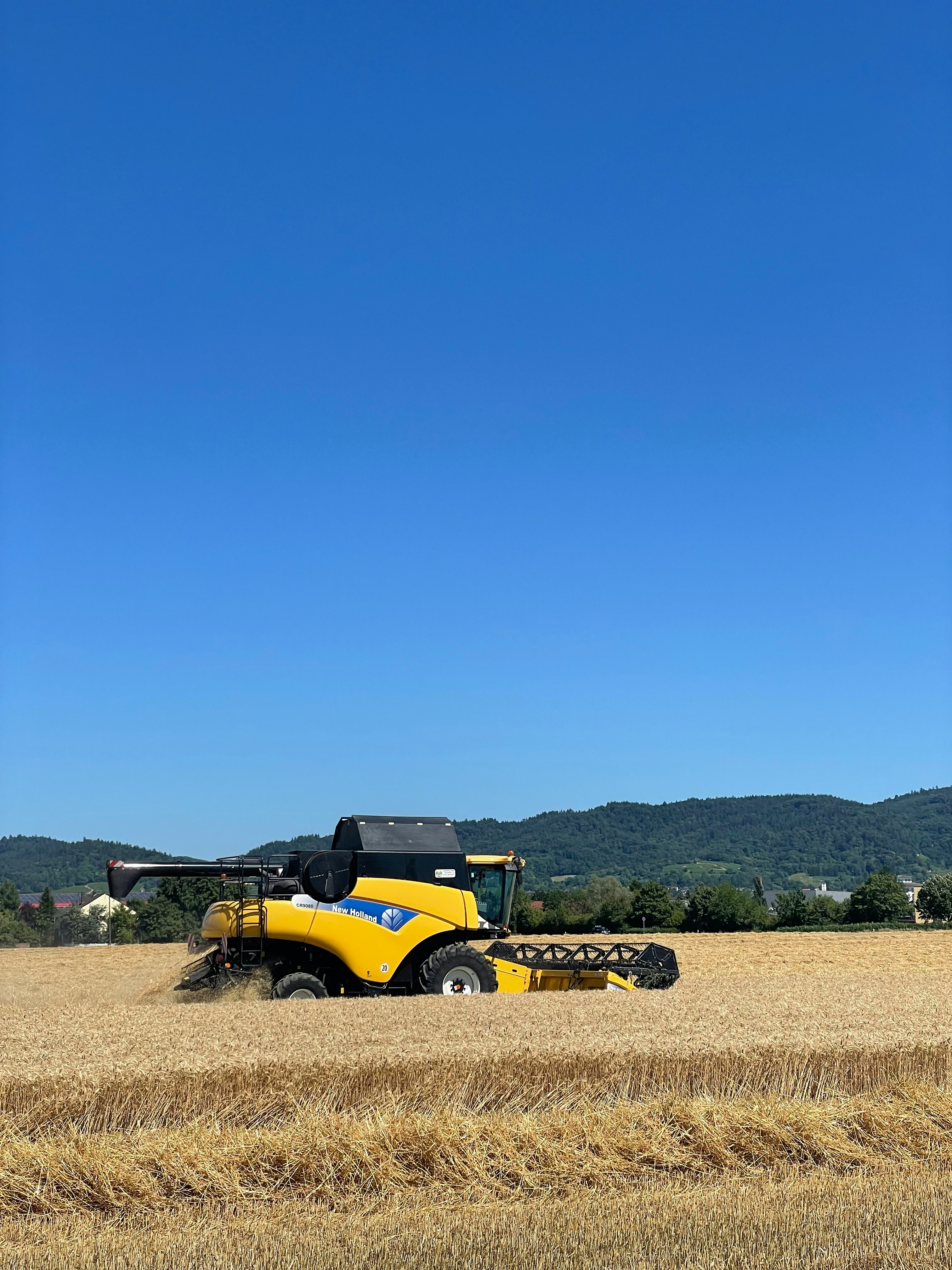 Un tracteur moderne travaillant dans un champ sous un ciel partiellement nuageux, illustrant le type d