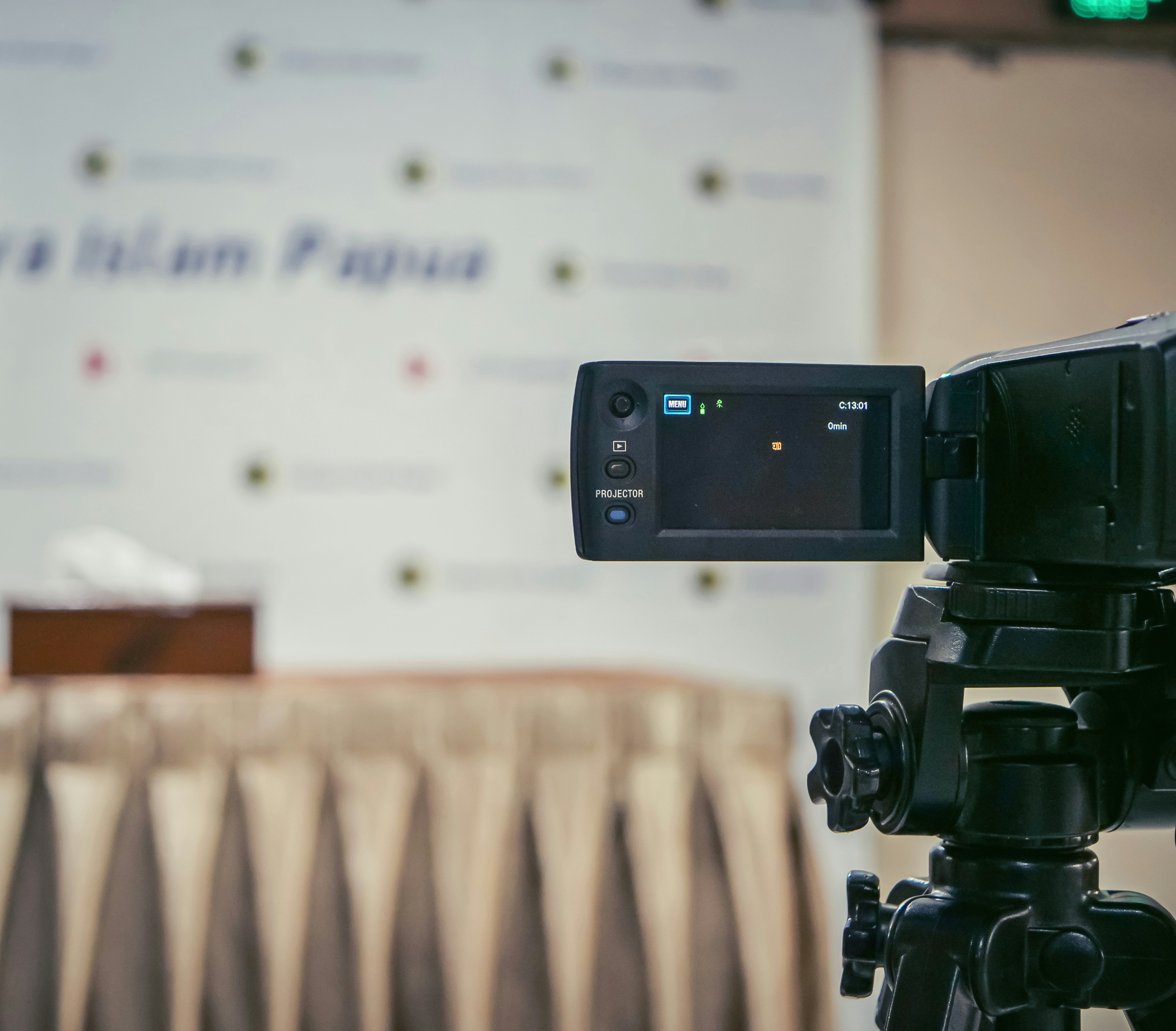 A professional consultant sits at a sleek, minimalist desk, gesturing thoughtfully during a video conference.