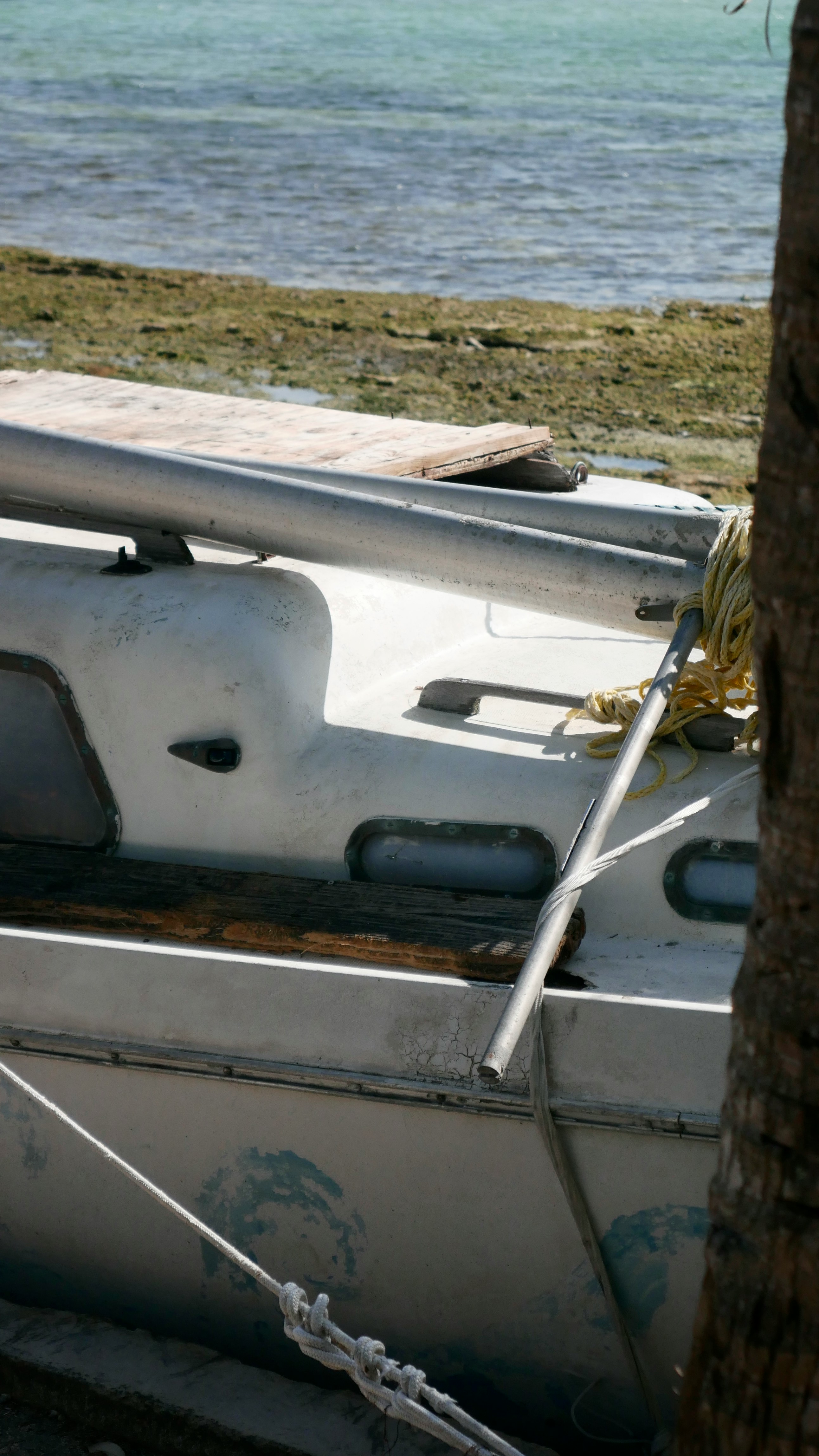 Un store bateau en lin blanc cassé, avec ses plis souples et élégants, diffuse une lumière douce dans une chambre à coucher sereine.
