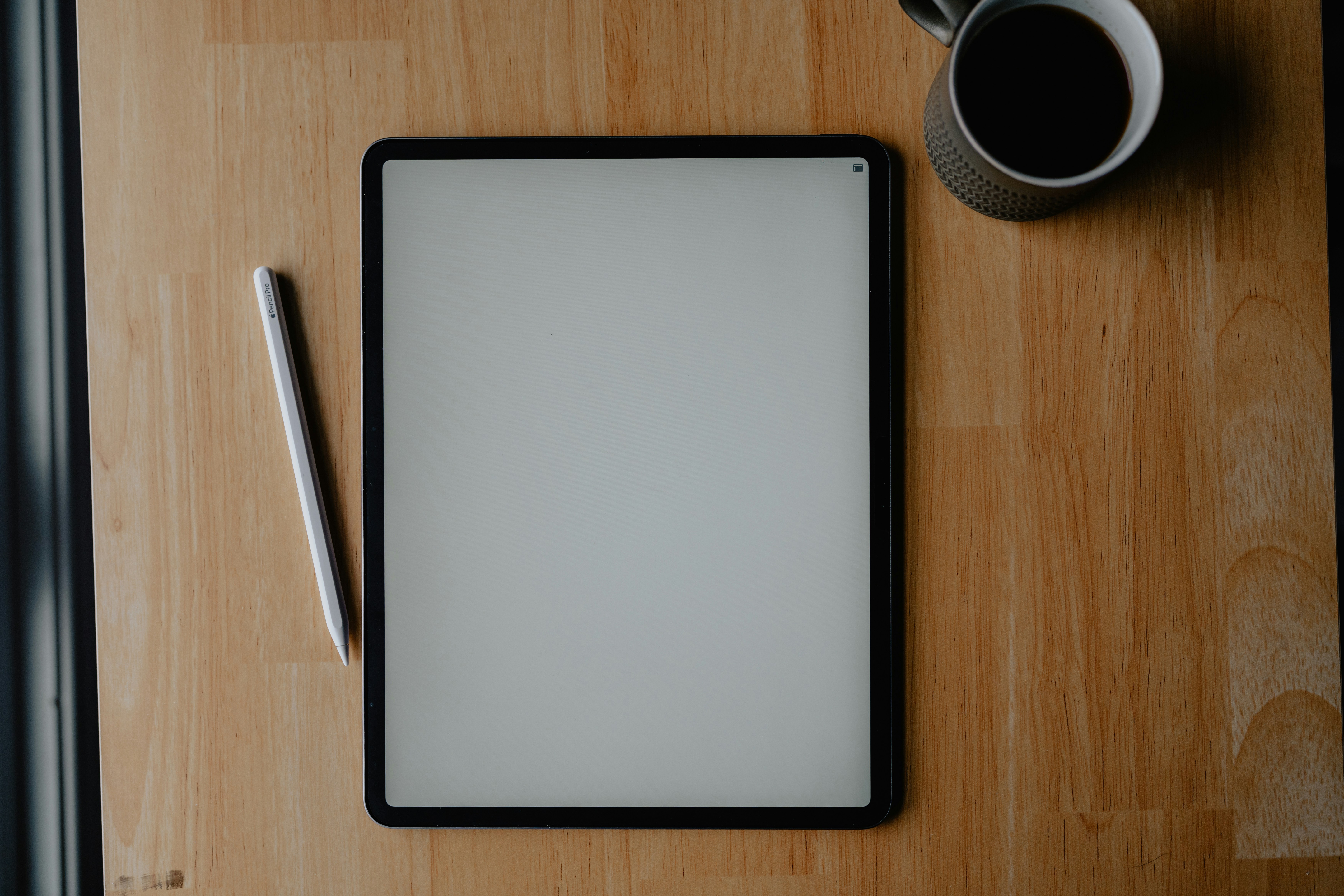 A close-up of hands typing on a laptop, with a creative workspace blurred in the background.