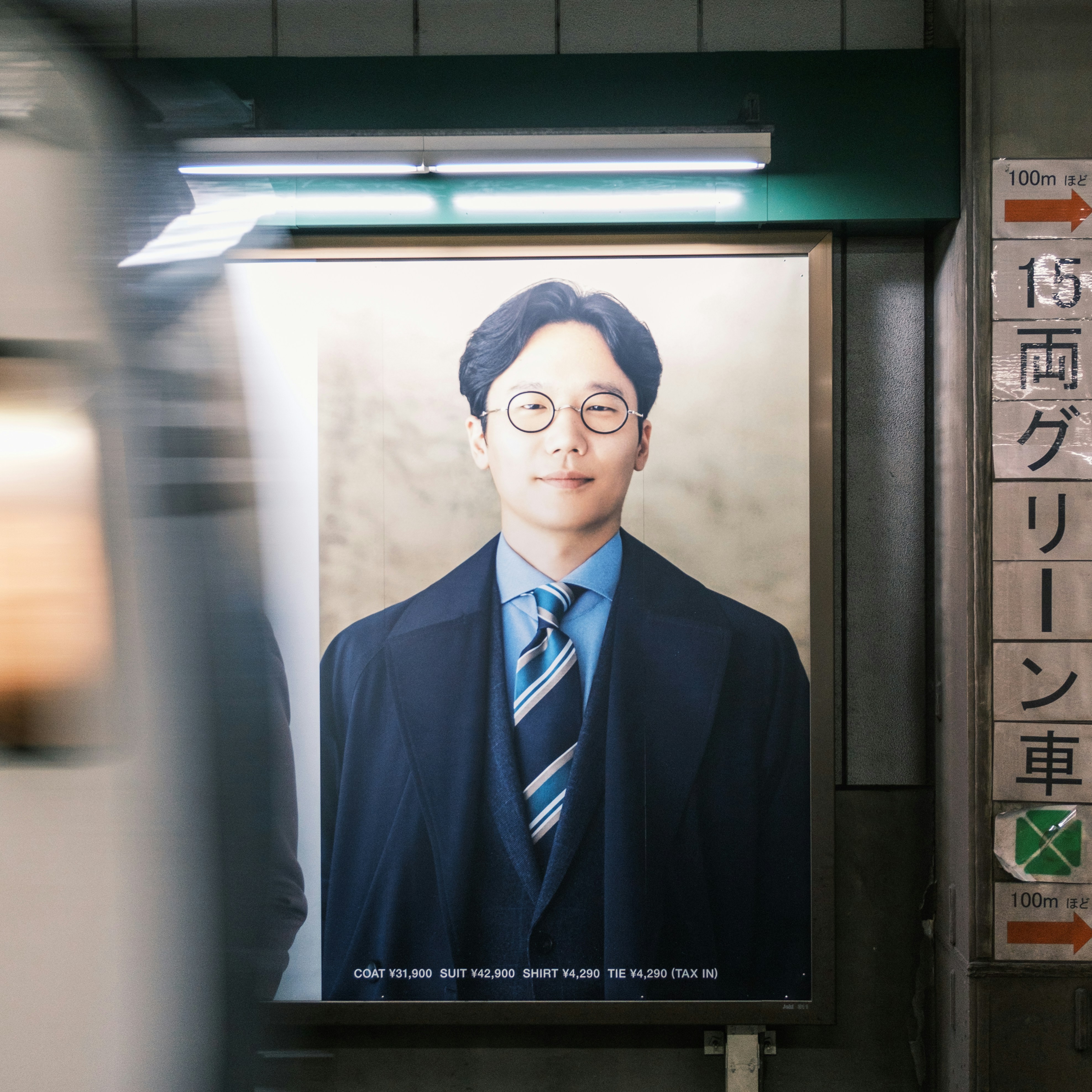 Un homme d'affaires examinant attentivement une affiche publicitaire grand format dans une station de métro.