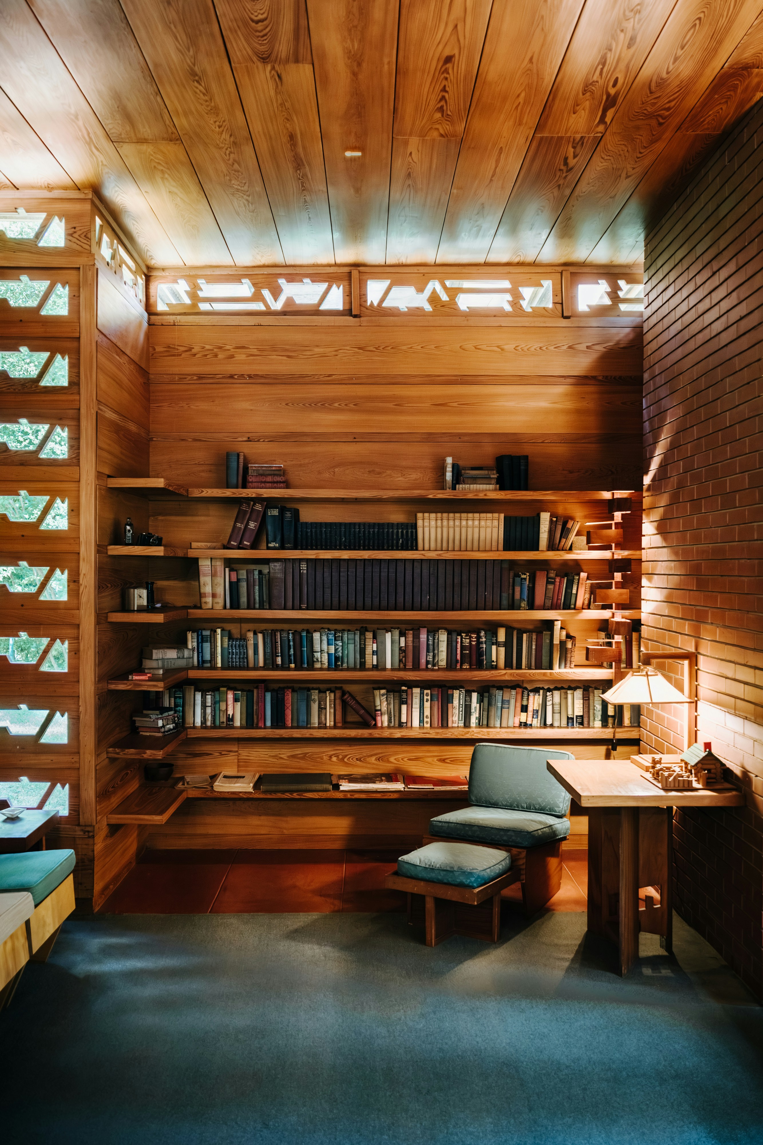 Une bibliothèque chaleureuse avec des fauteuils en cuir et une lumière douce, qui évoque le savoir et la tradition.