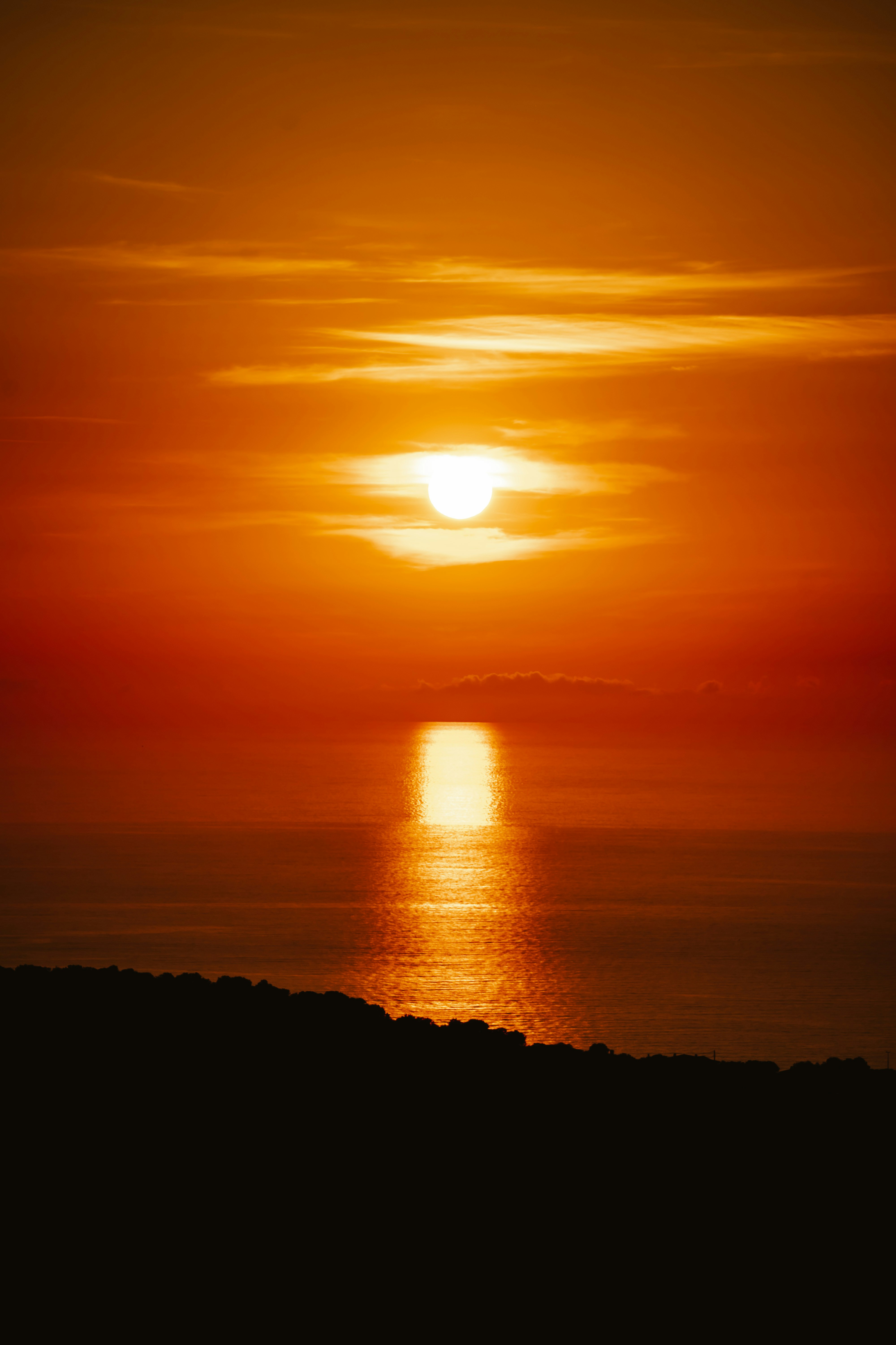 Une silhouette se dresse face à un immense horizon au soleil couchant, une image puissante qui évoque l'apaisement et l'espace que l'on retrouve en soi.