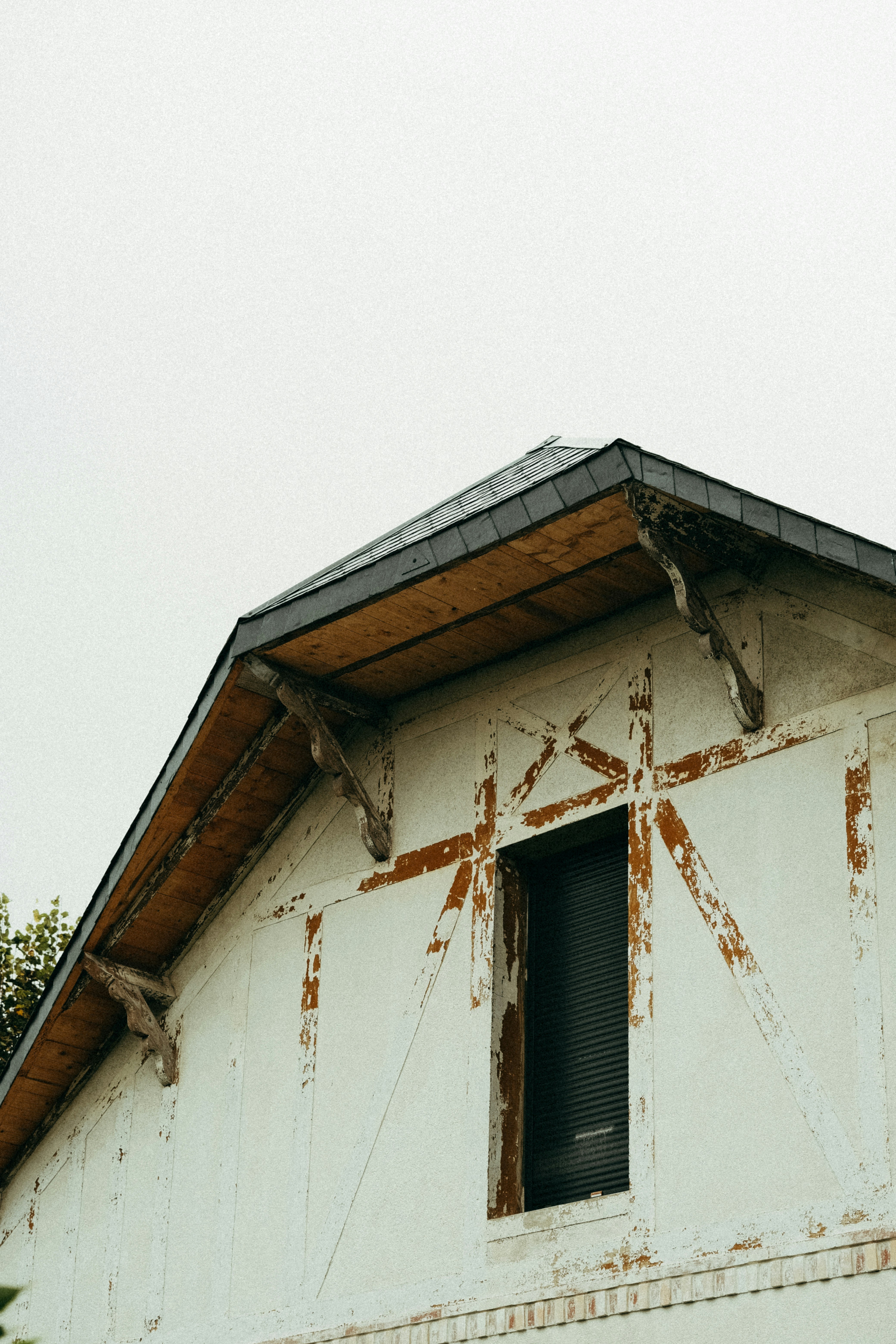 Un toit en tuiles de couleur vive récemment peint, brillant sous le soleil, avec une maison bien entretenue en arrière-plan.