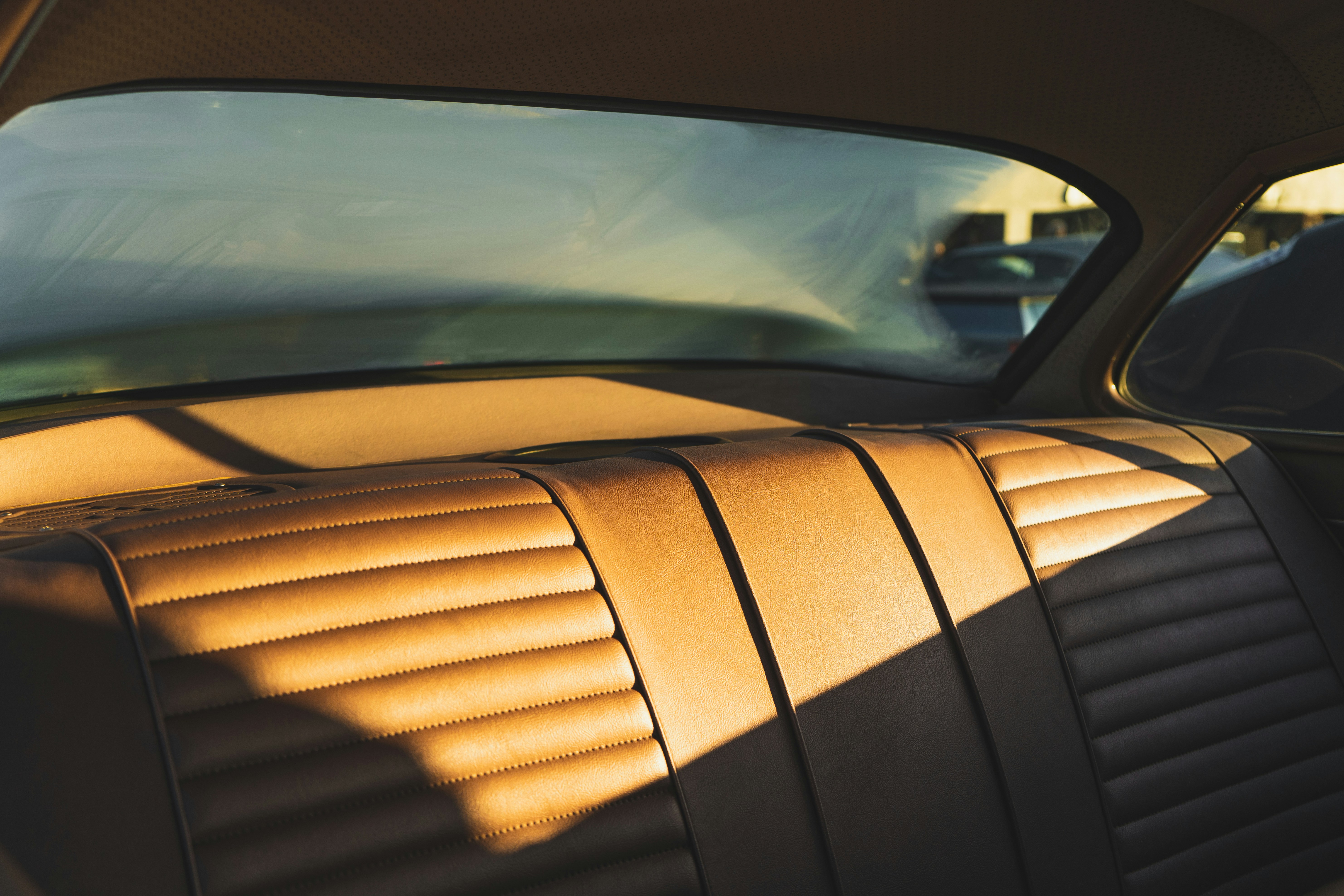 Interior of a luxury car clean and tidy with tinted windows offering a view on the road, peaceful atmosphere