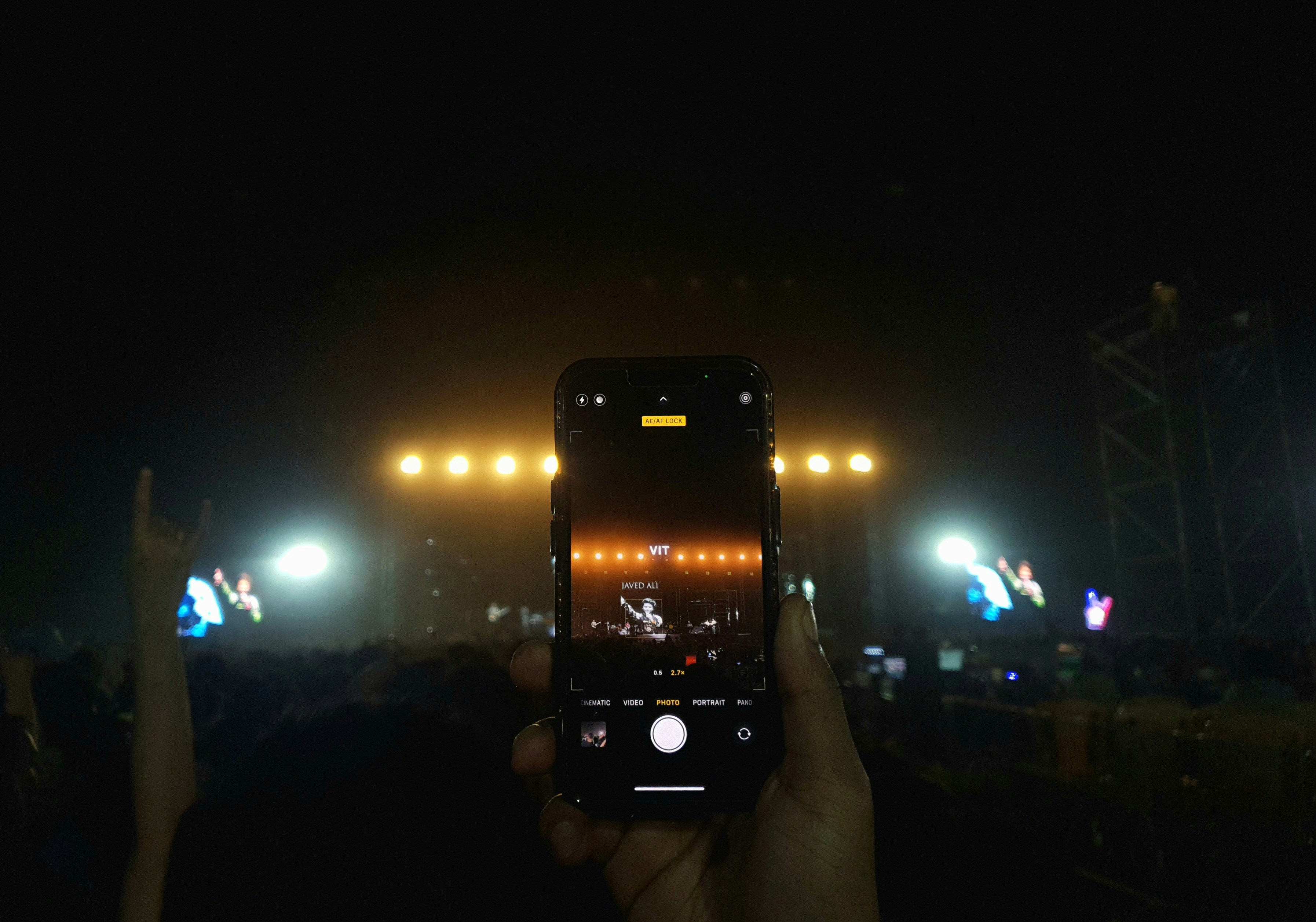 A smartphone scanning a QR code on a drum kit at a concert
