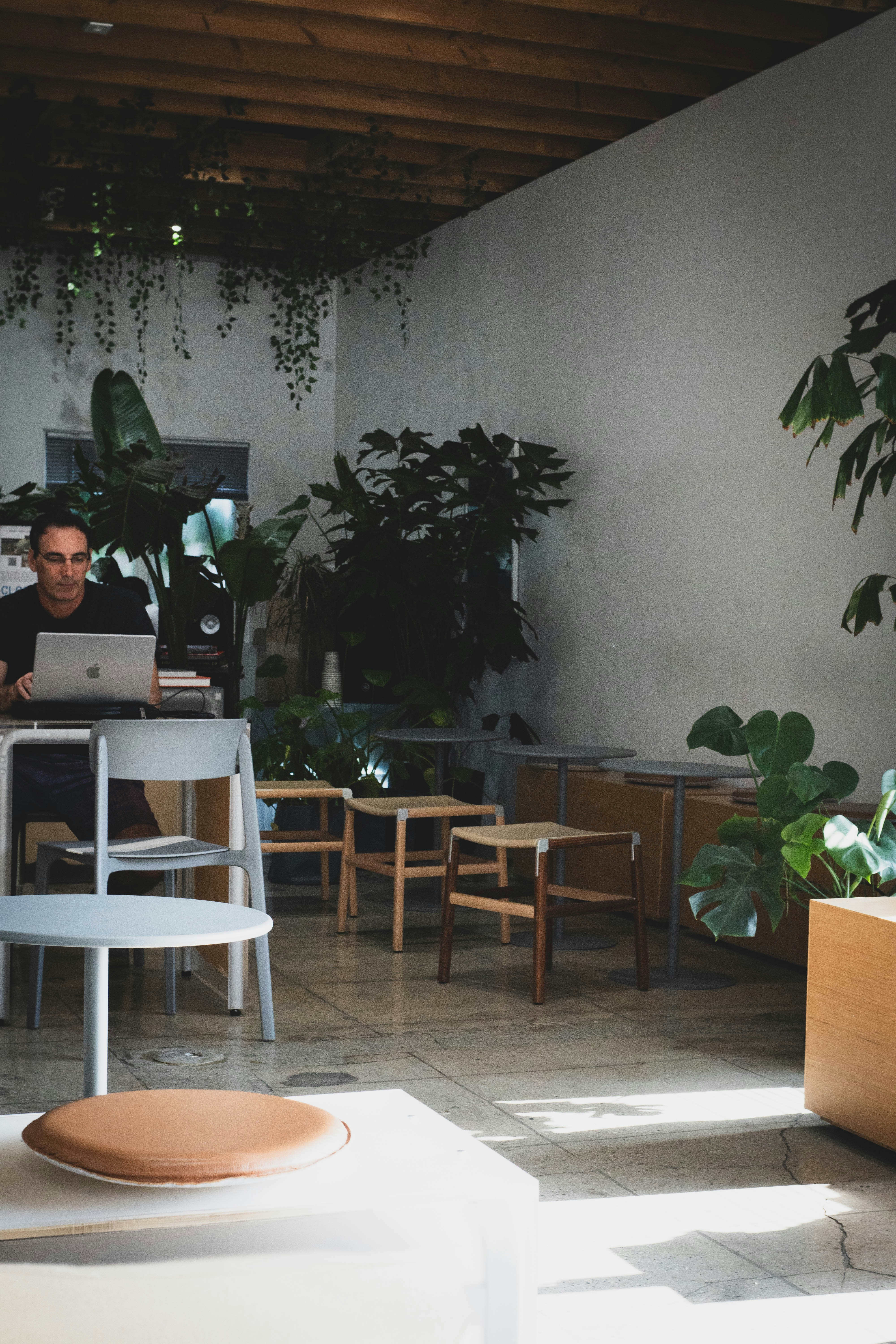 Entrepreneur smiling while working on a laptop in a bright modern coffee shop