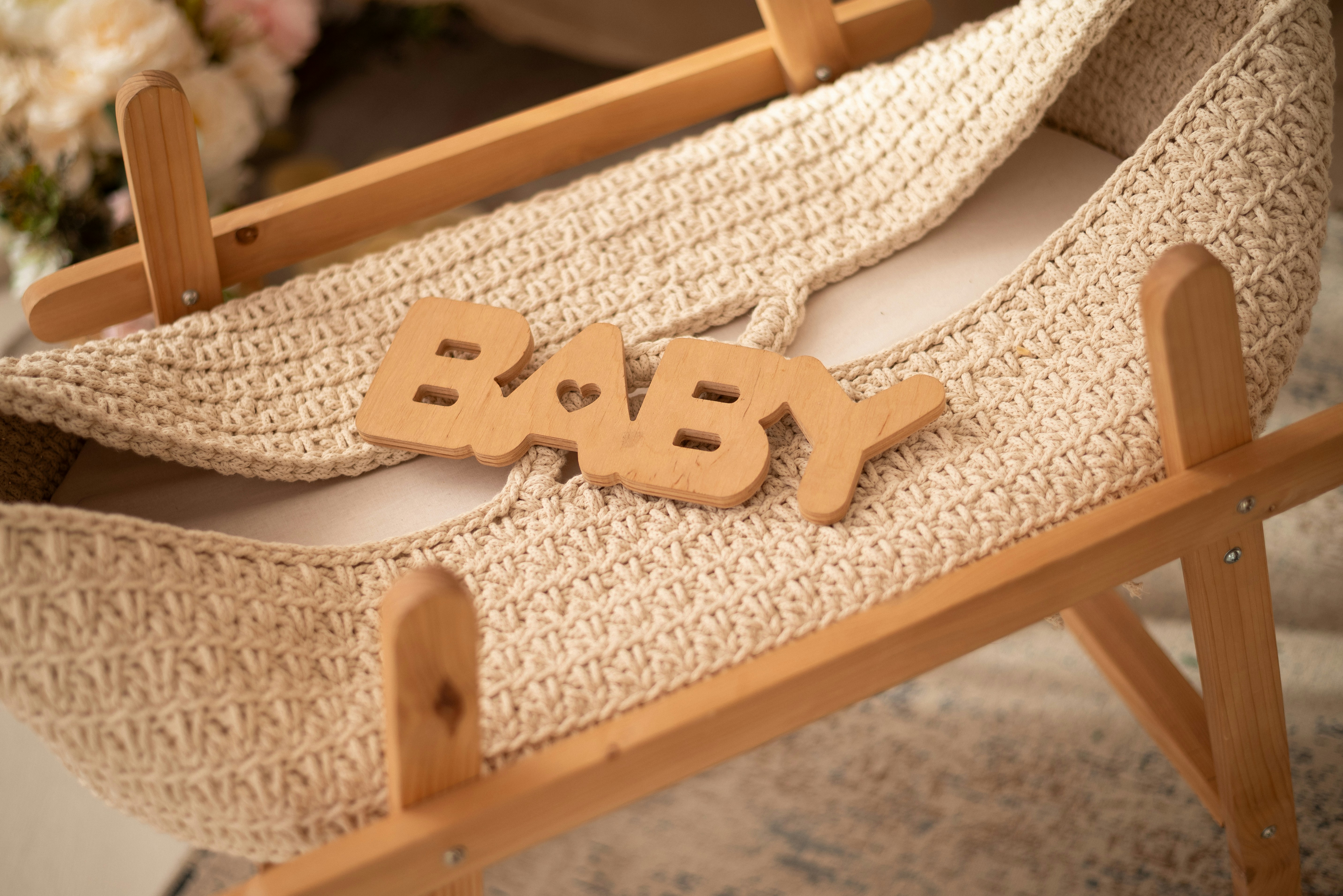 Soft focus image of baby shoes and a positive pregnancy test on a wooden table
