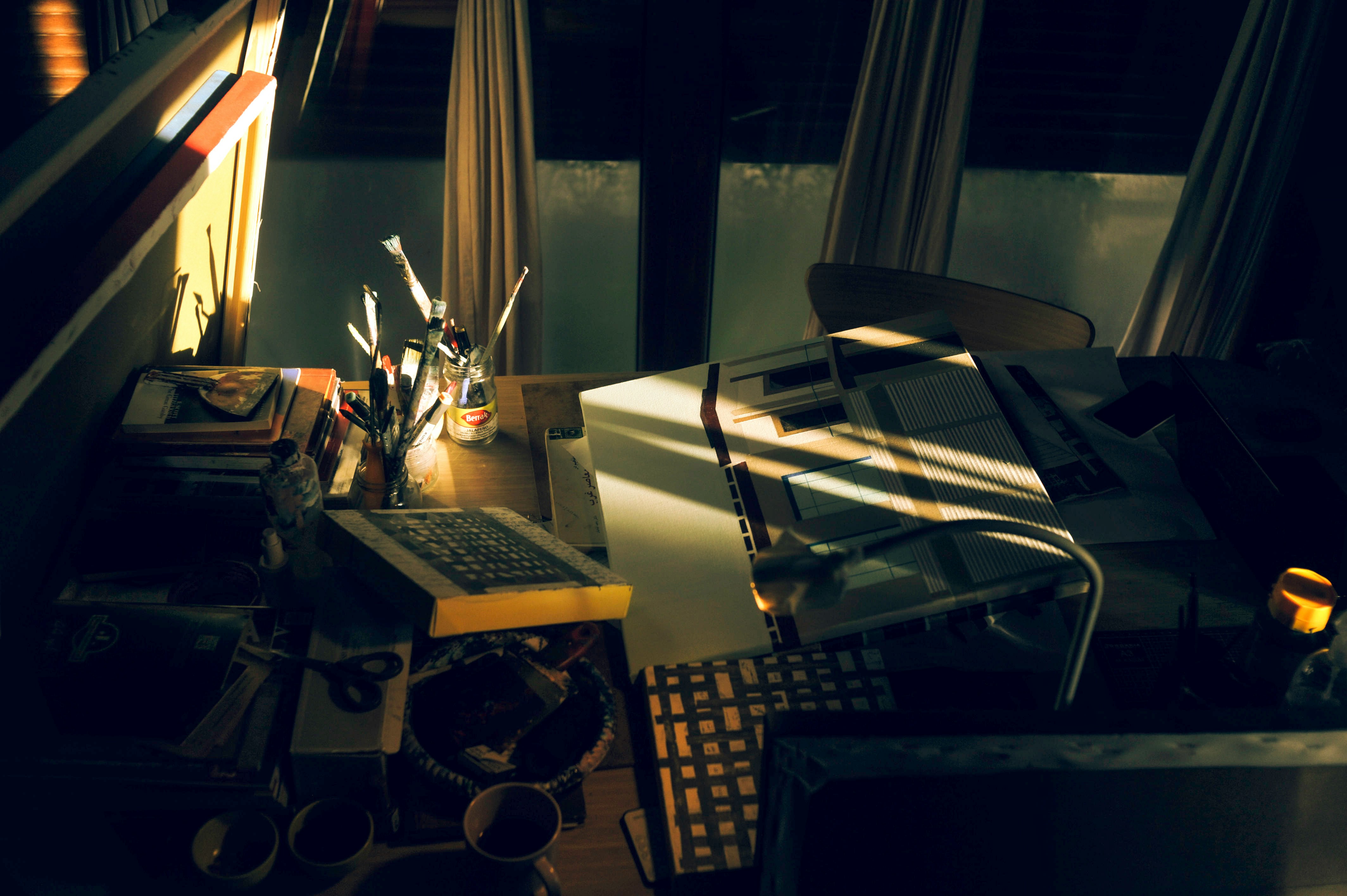 A stressed business owner sitting at a messy desk looking at a laptop screen late at night