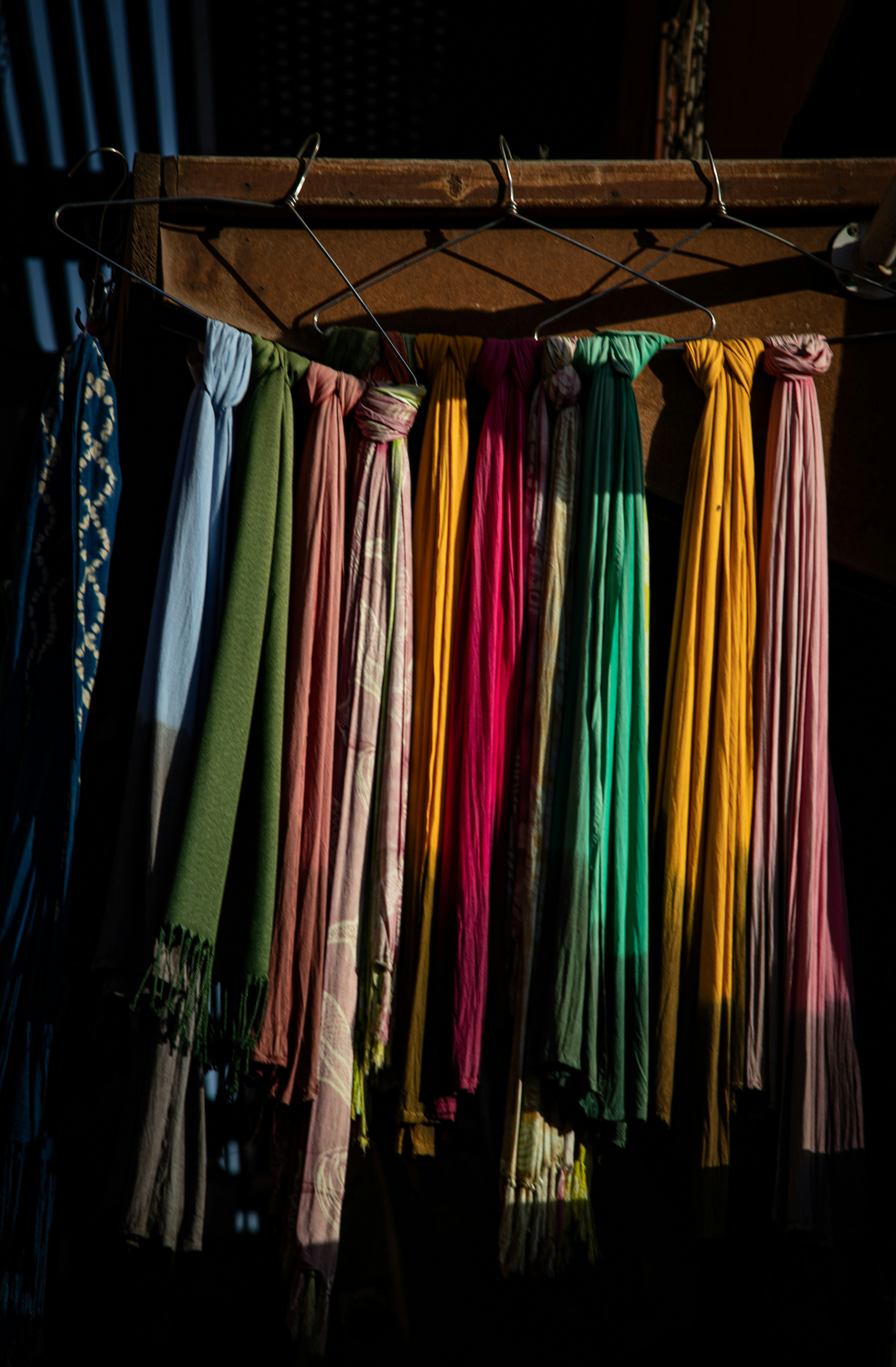 Variety of colorful vintage clothes hanging on a rack in a bright store