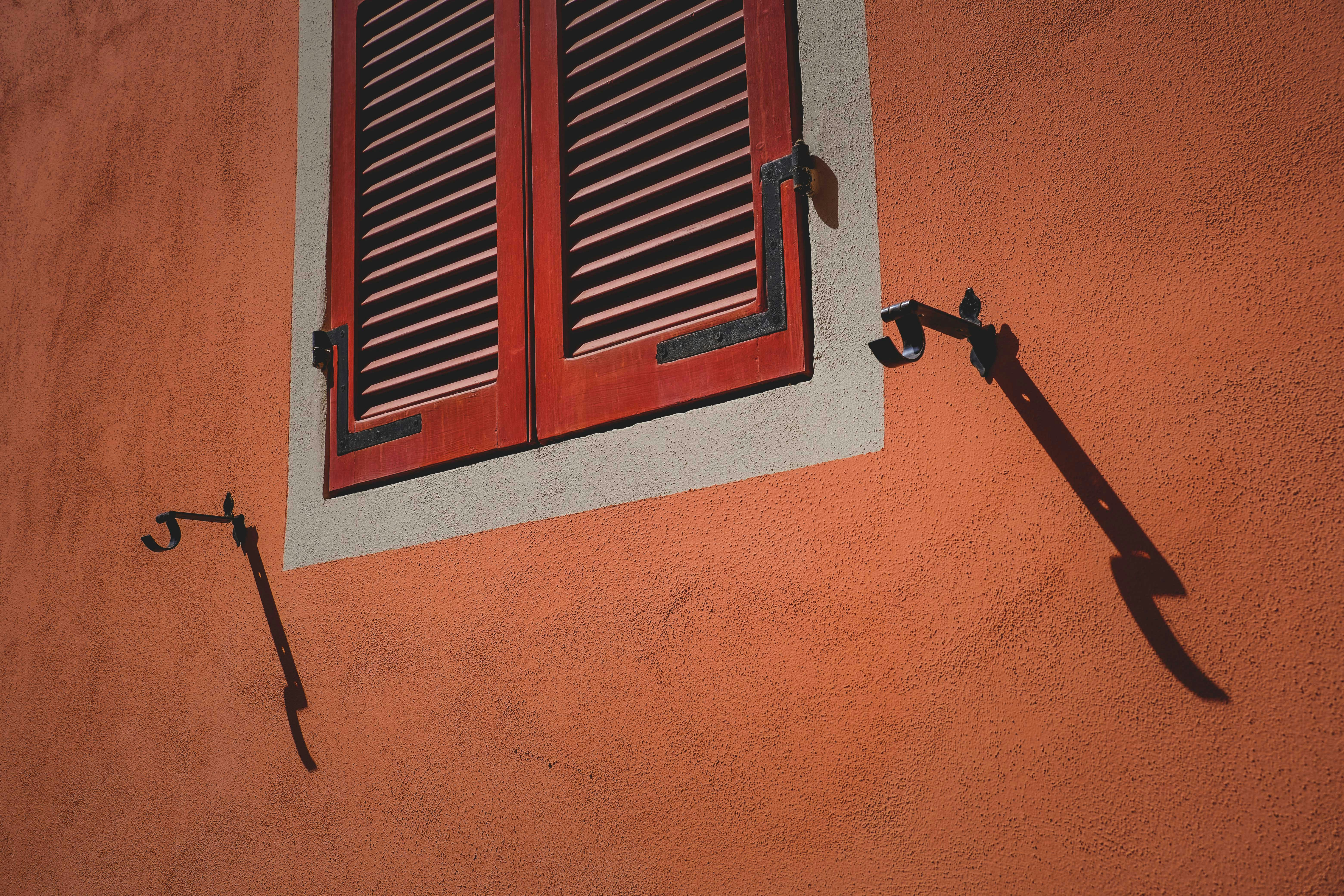 Home office setup with black aluminium blinds partially open blocking glare on monitor