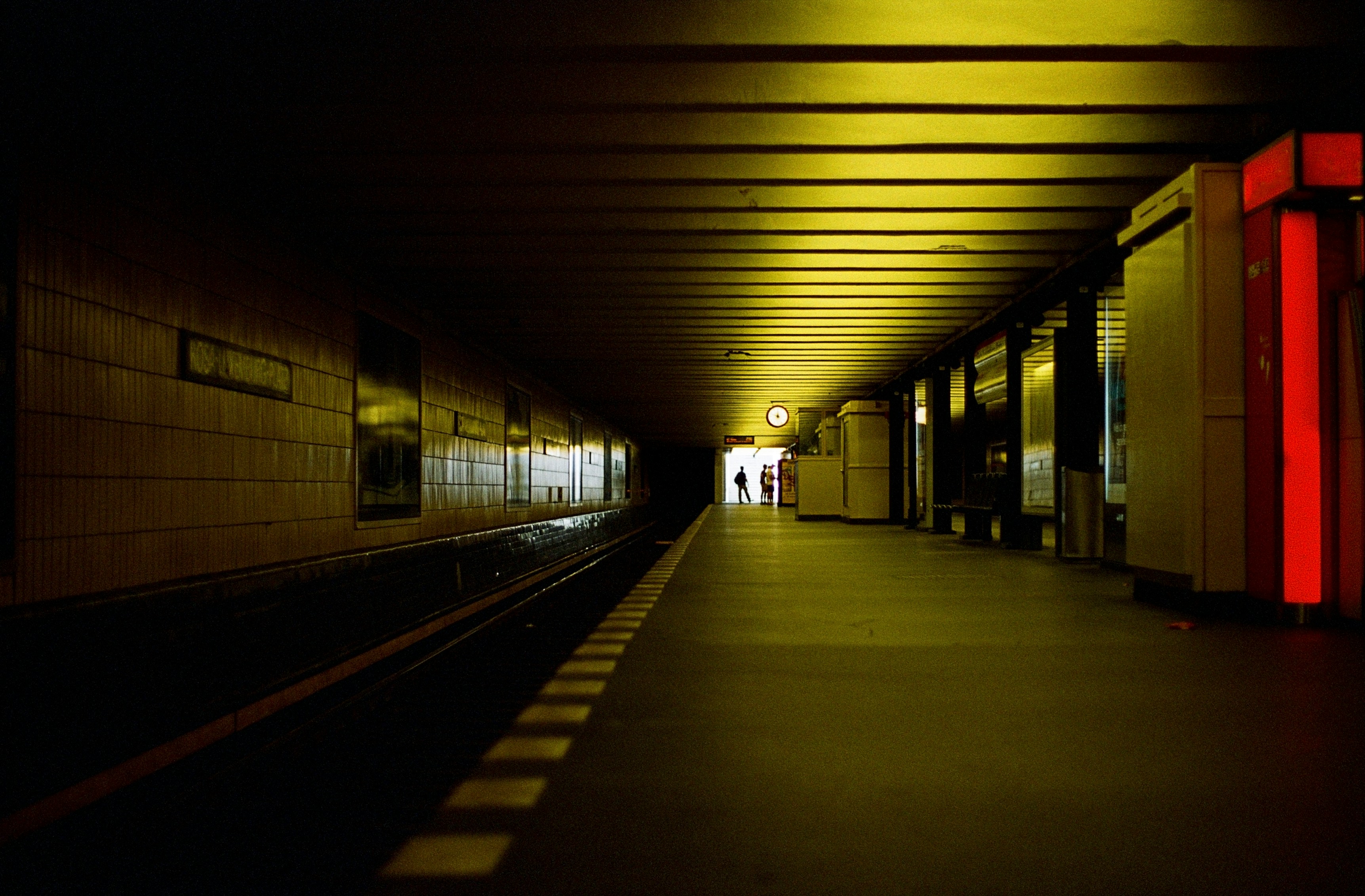 A dark, eerie underground subway station with dim lighting, representing the ghost stations of Berlin.