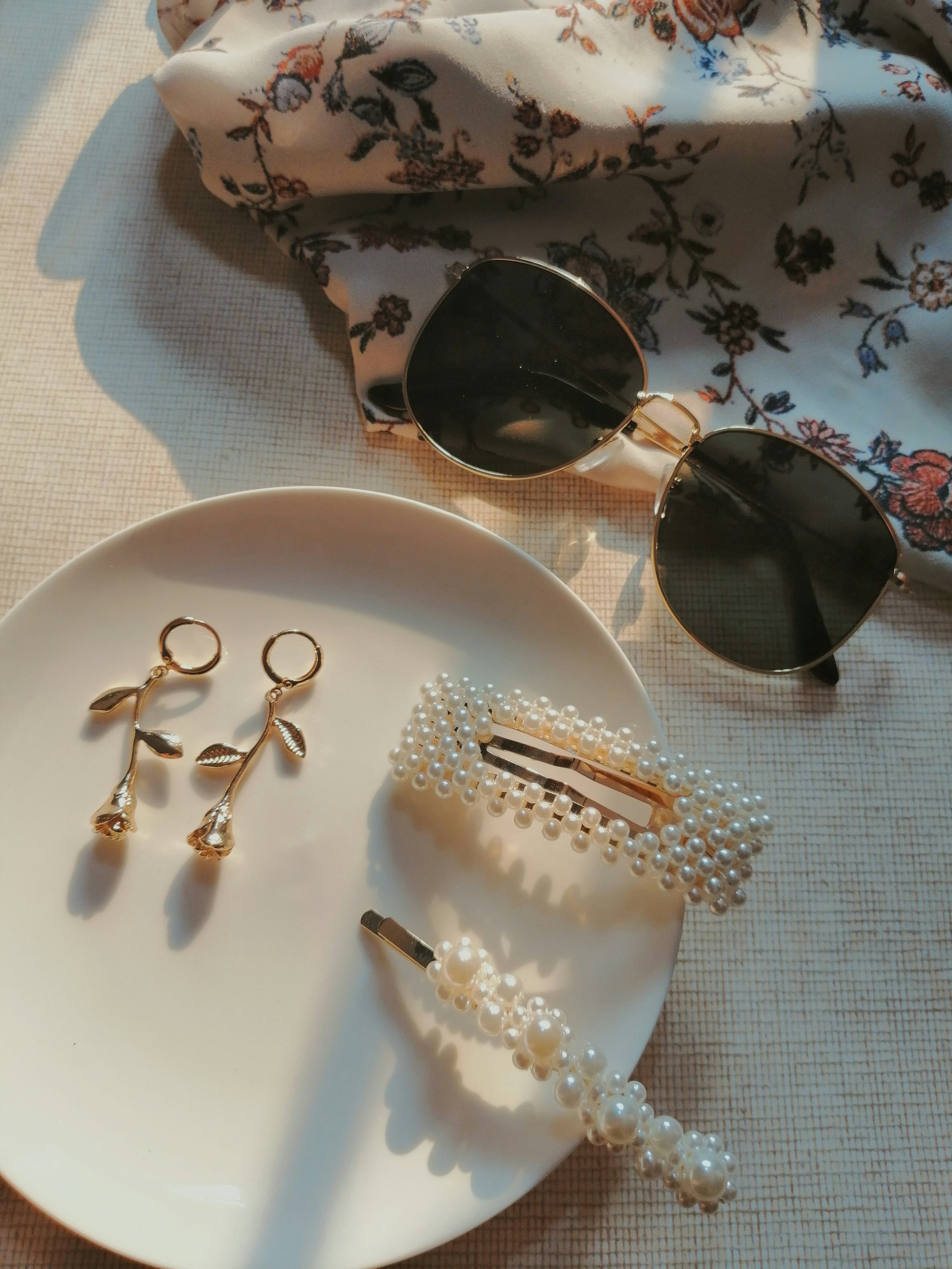 Fashion styling arrangement on a table showing a complete outfit with accessories, sunglasses, and shoes