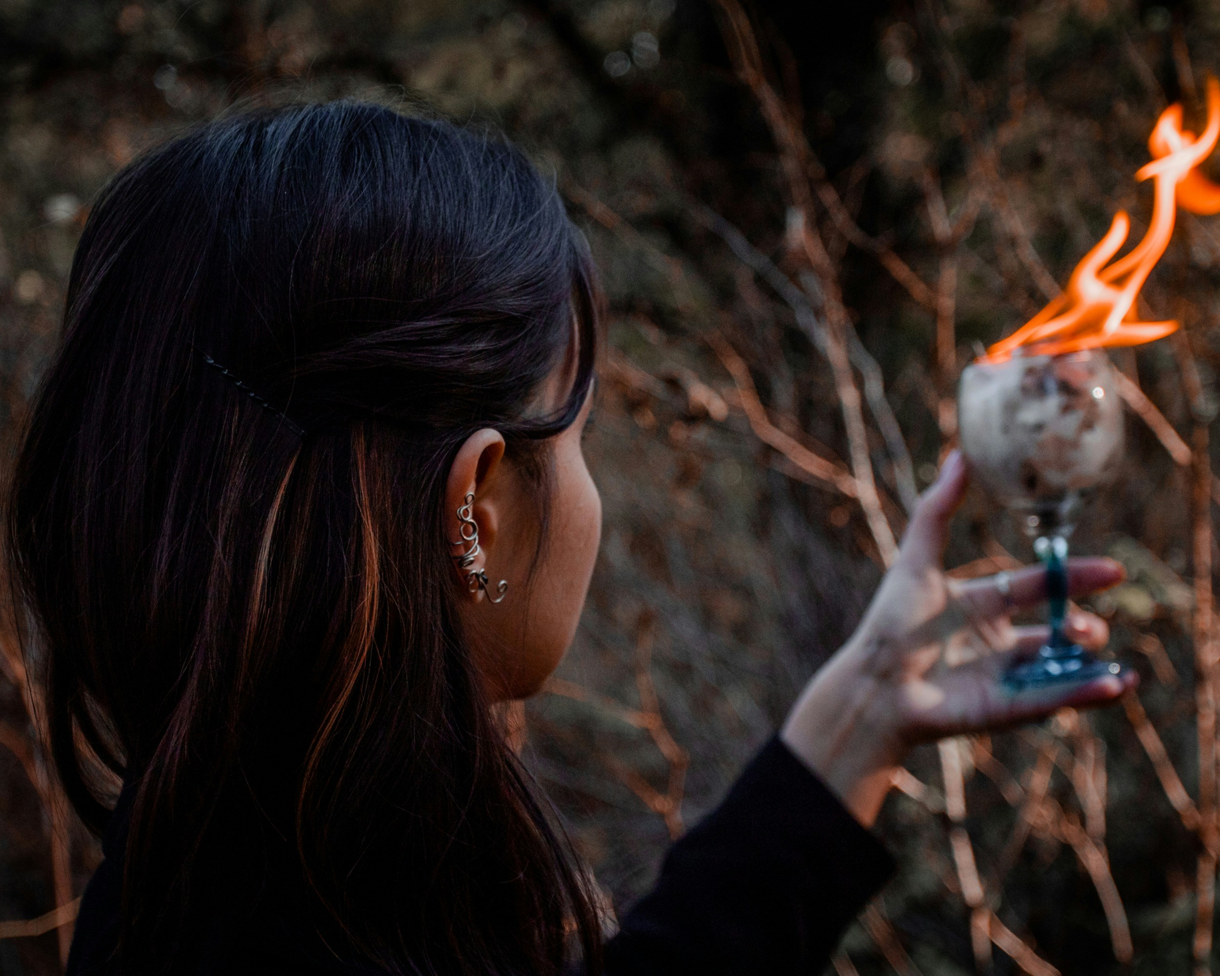 Close up of healing crystals, sage smoke, and candles on a wooden table, creating a mystical atmosphere