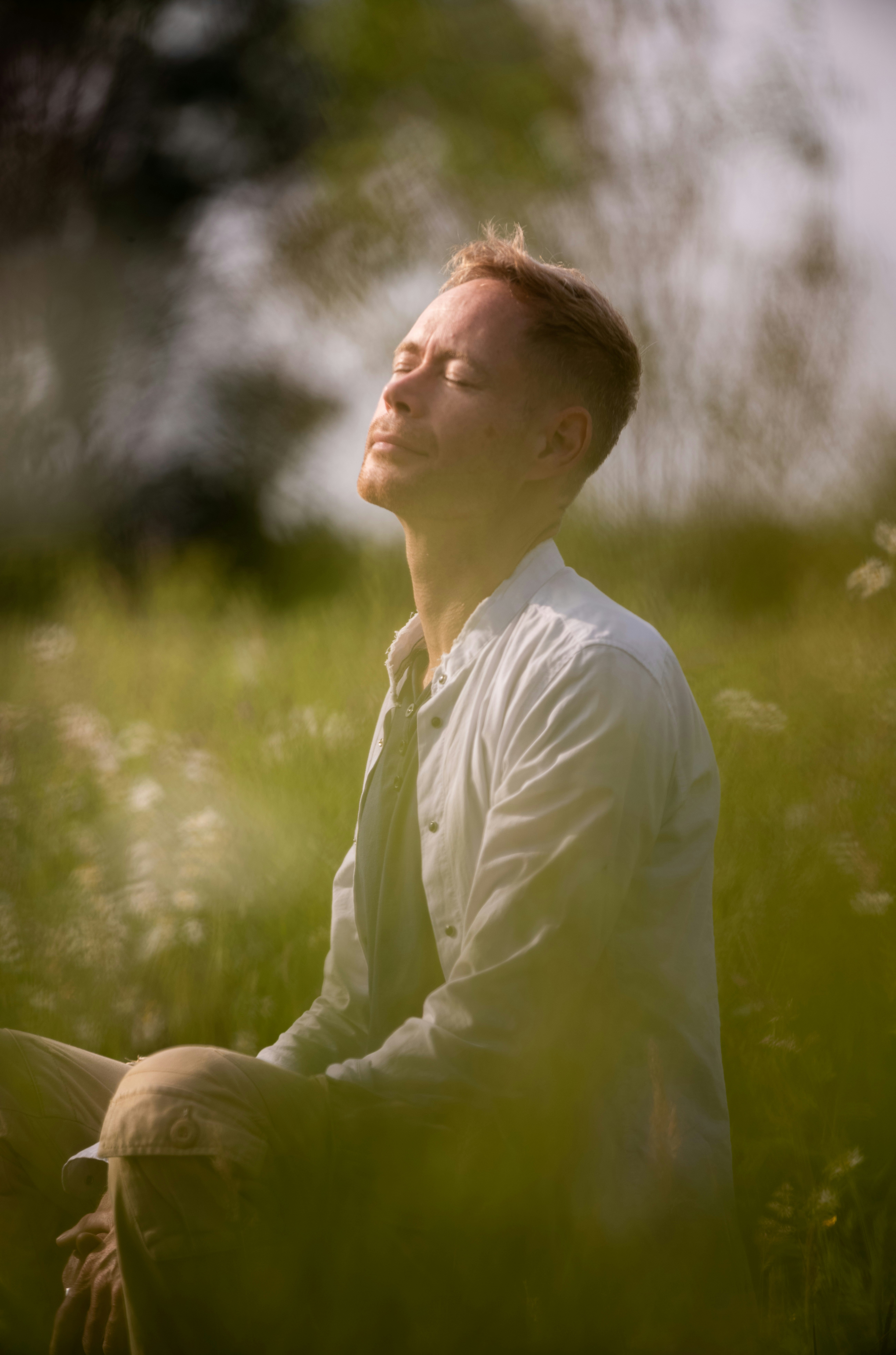 A calm person meditating outdoors, symbolizing the result of a successful energy clearing
