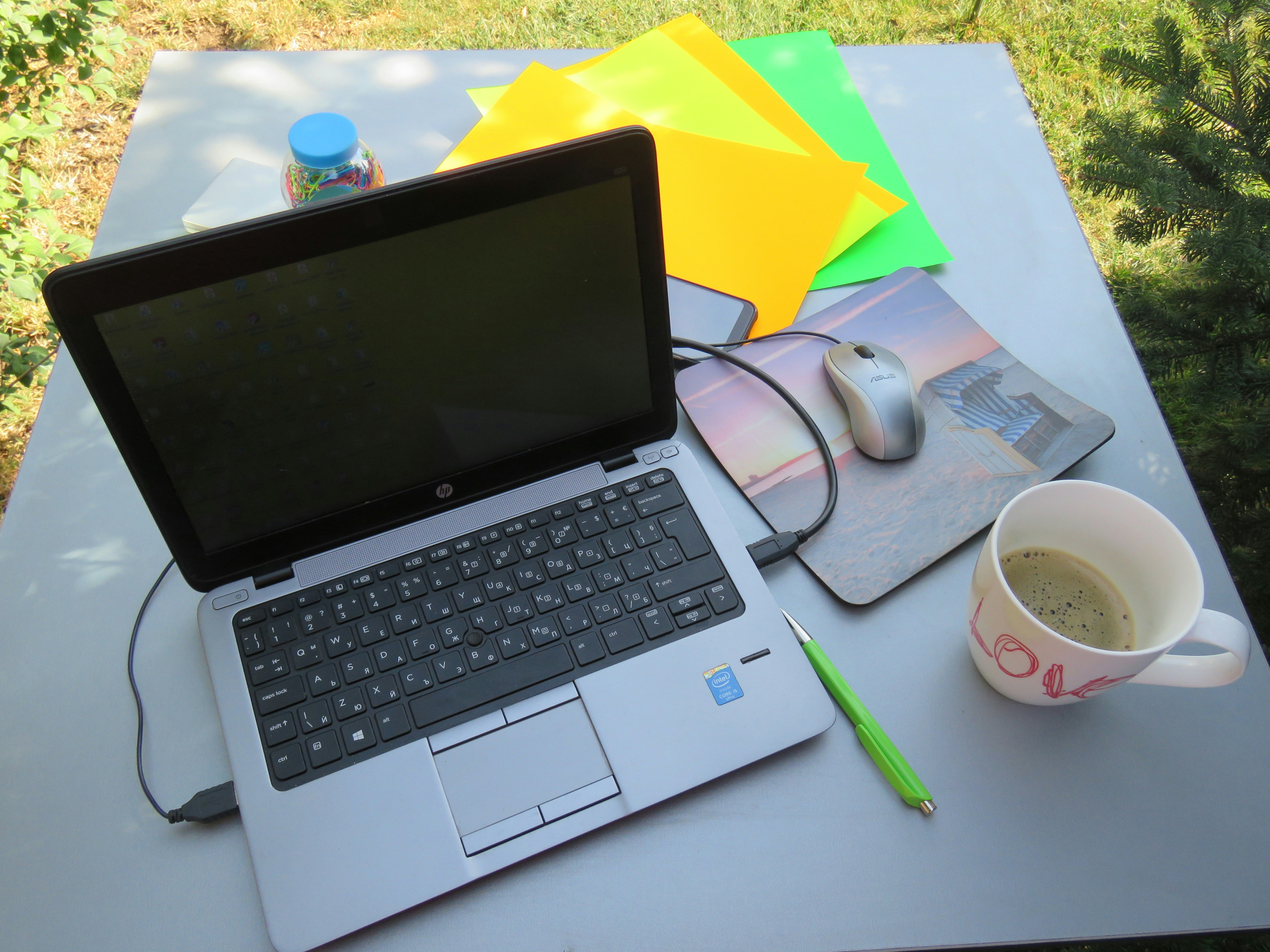 Coffee cup next to a laptop showing a calendar with green checkmarks