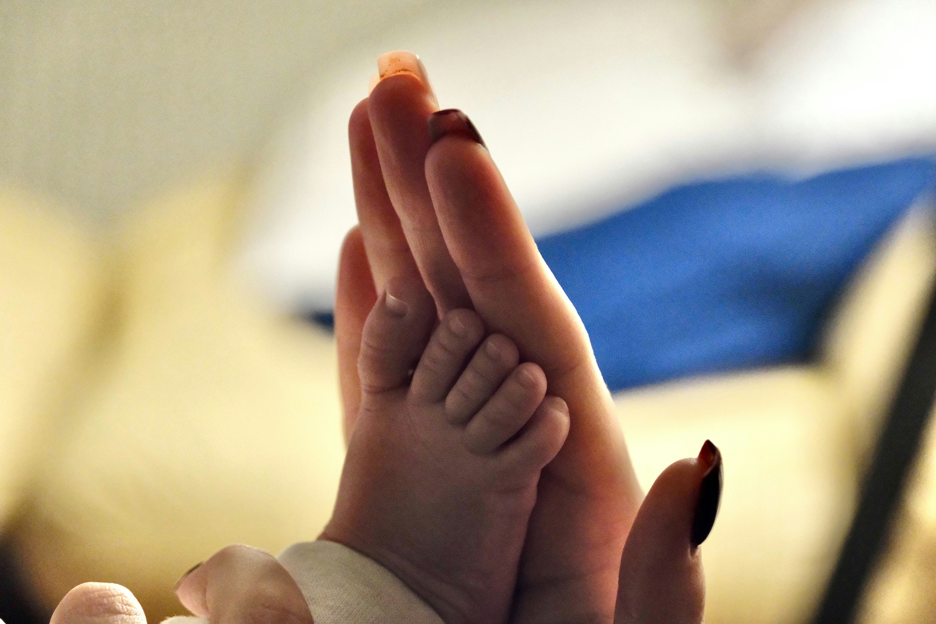 Soft artistic photo of newborn baby feet in mother's hands, black and white minimalist style