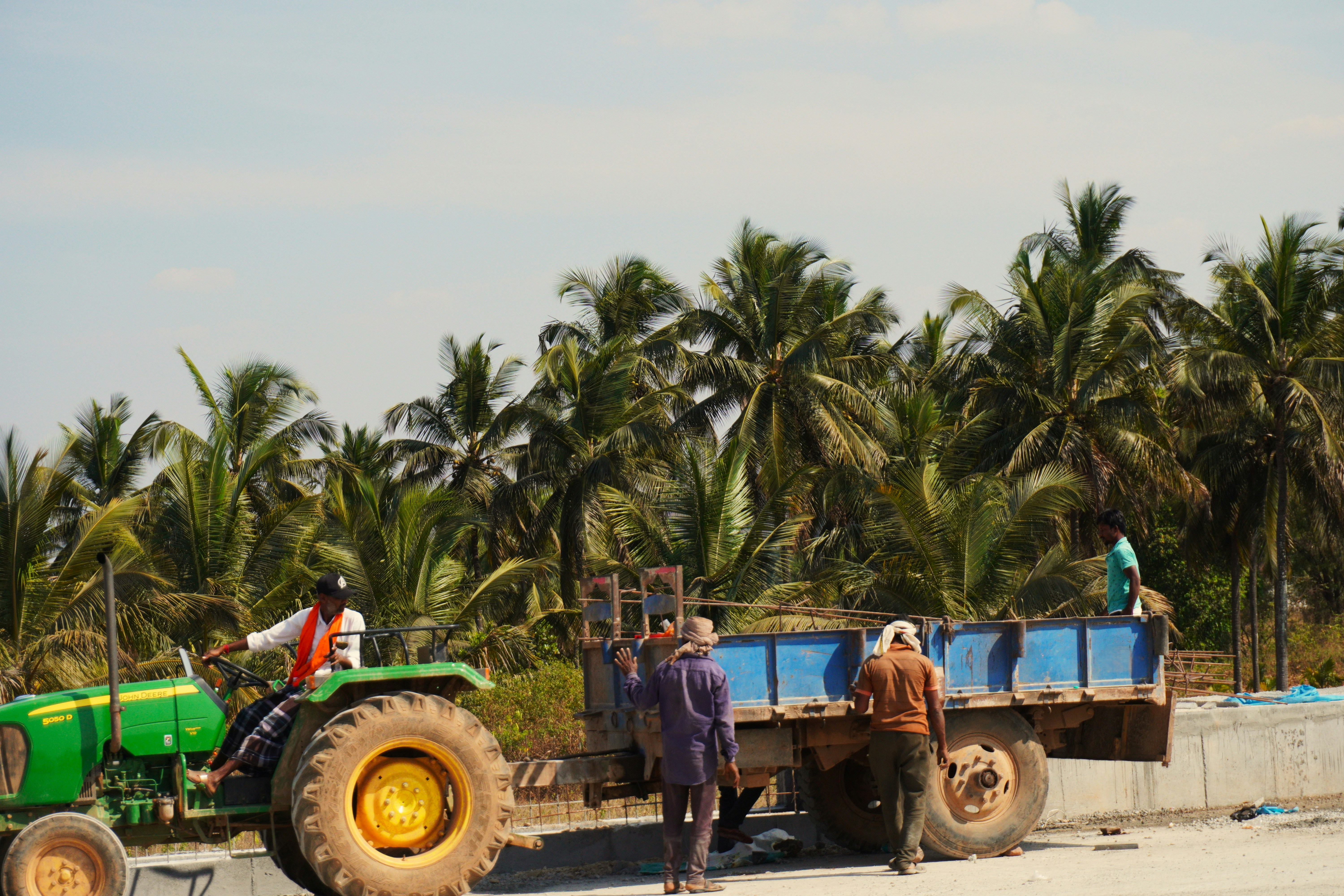 Farmer and seller shaking hands in front of a tractor dealing agreement