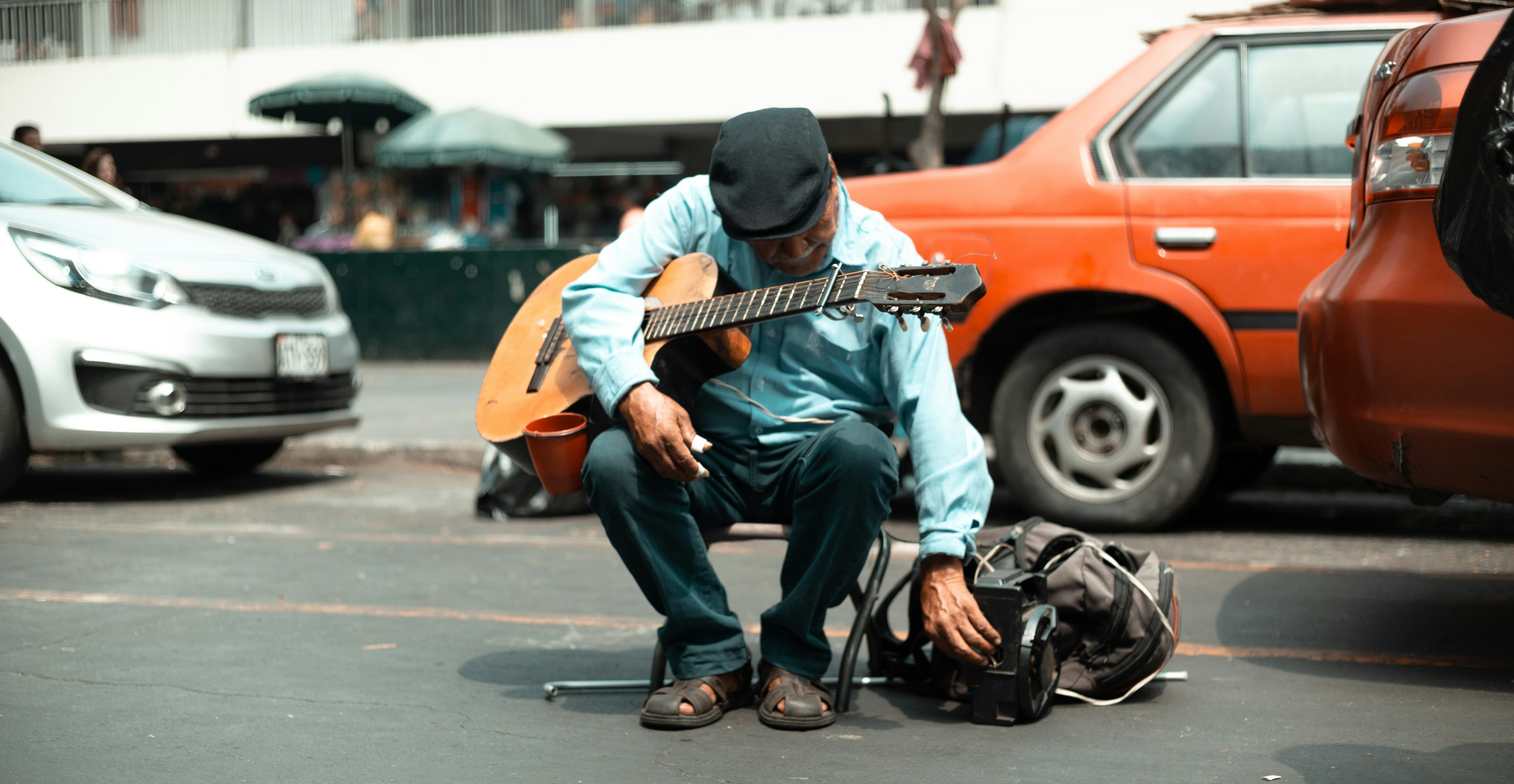 Unsplash image of a street musician playing guitar with a phone displaying a QR code nearby