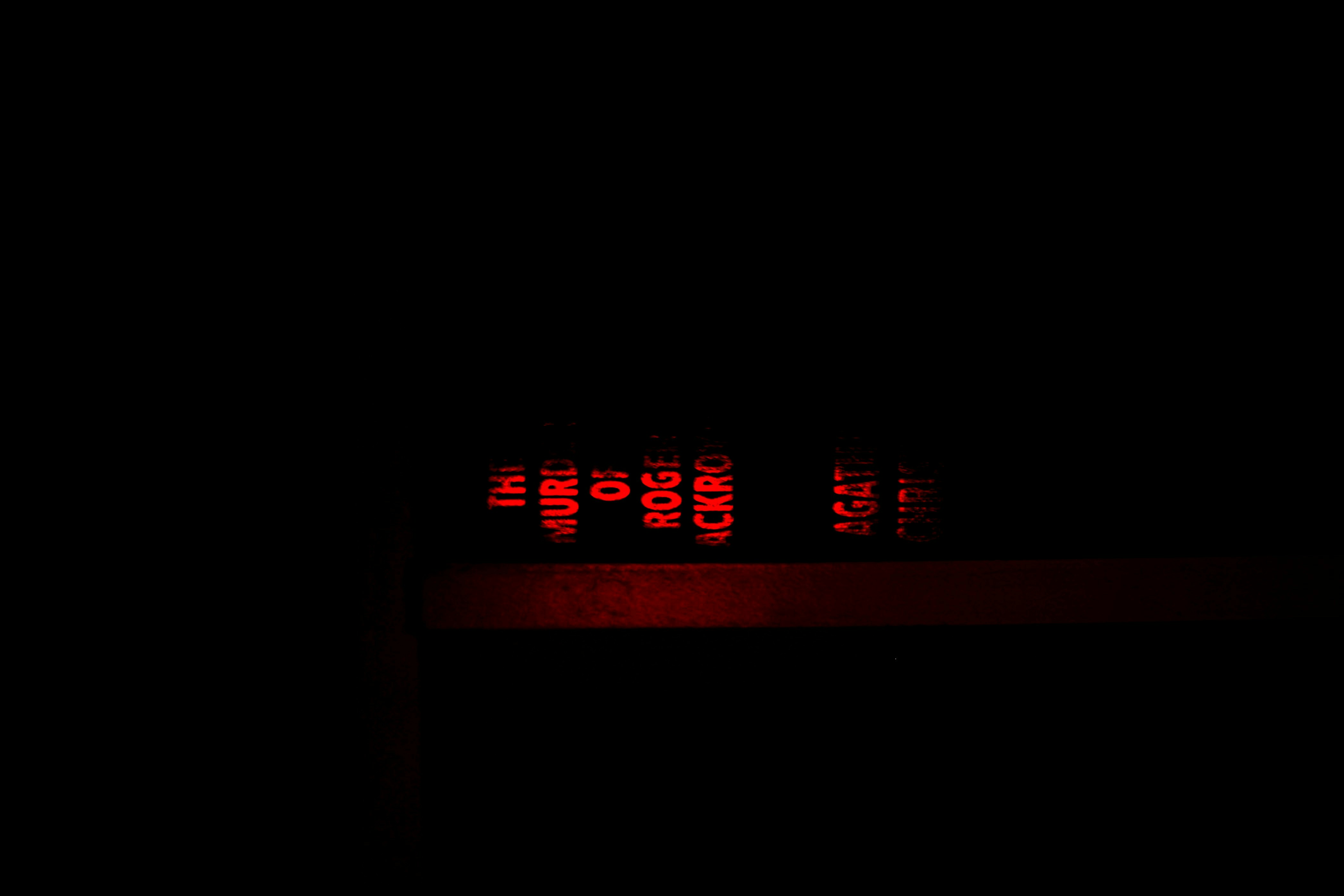 A blurred digital clock showing 3:33 AM in a dark room giving a spooky vibe