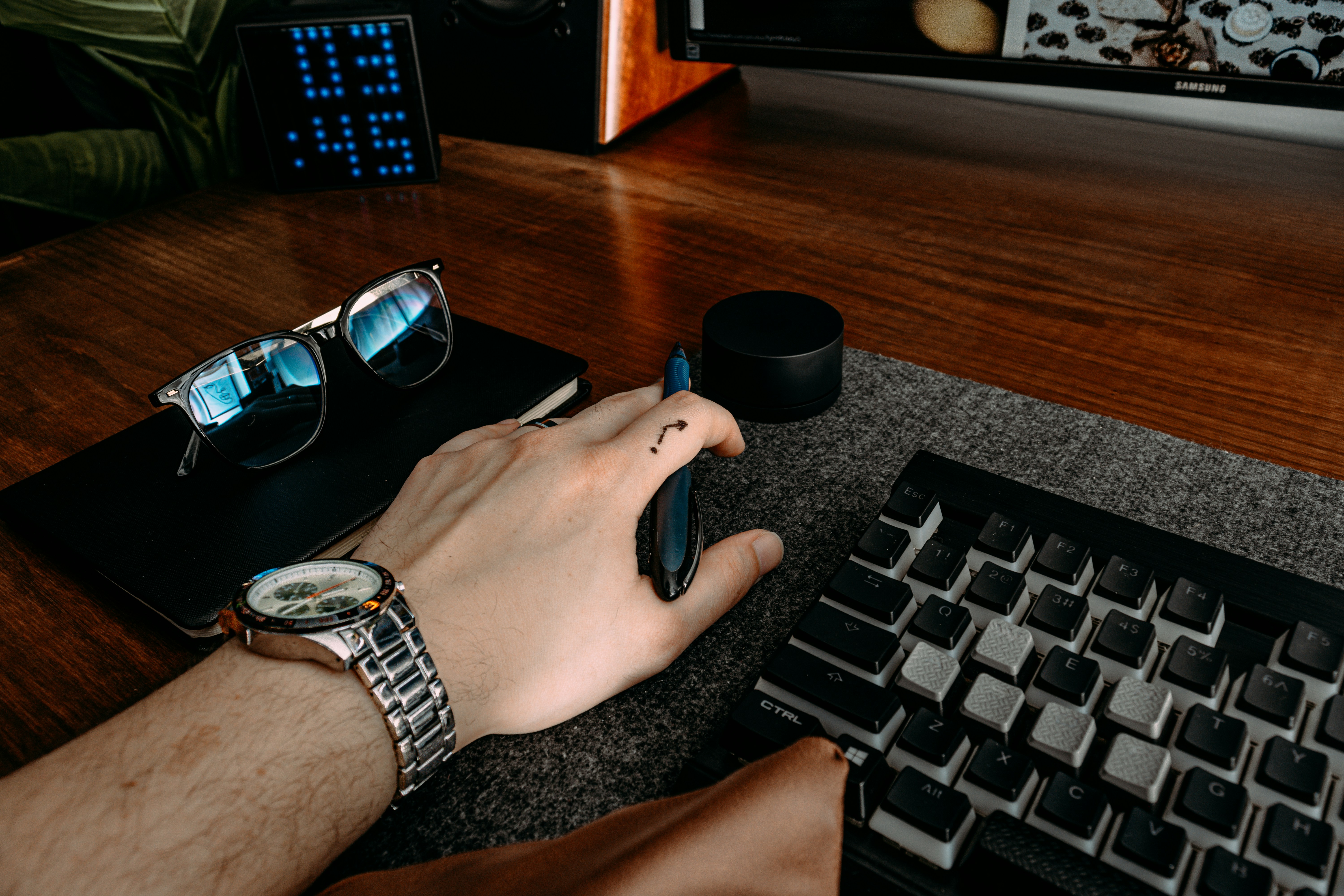 Close up of a hand typing on a keyboard with code reflection in glasses