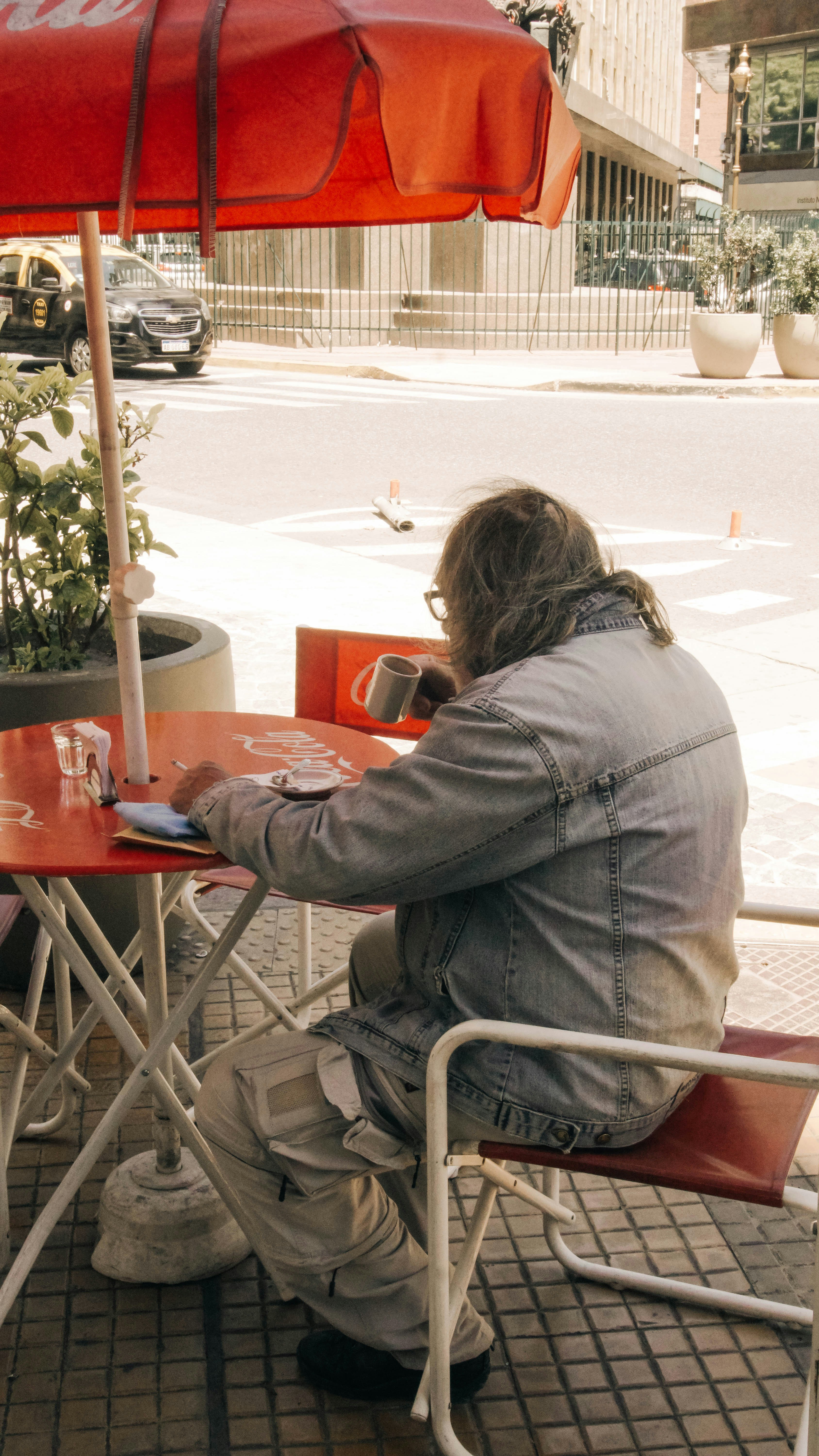 Person working on laptop in a modern coffee shop with blur background