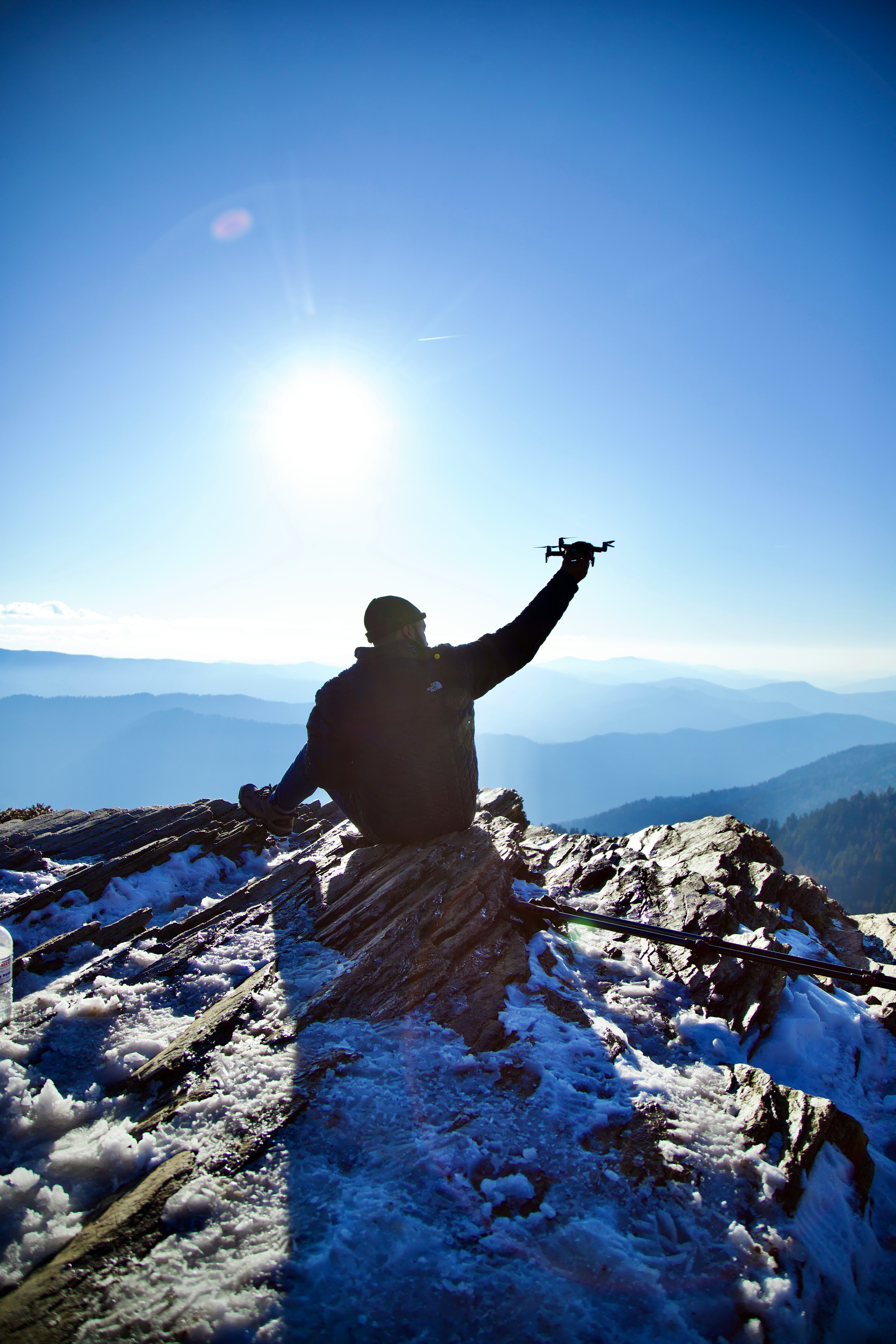 A person standing on top of a mountain with arms open, symbolizing freedom and breaking free from mental chains.
