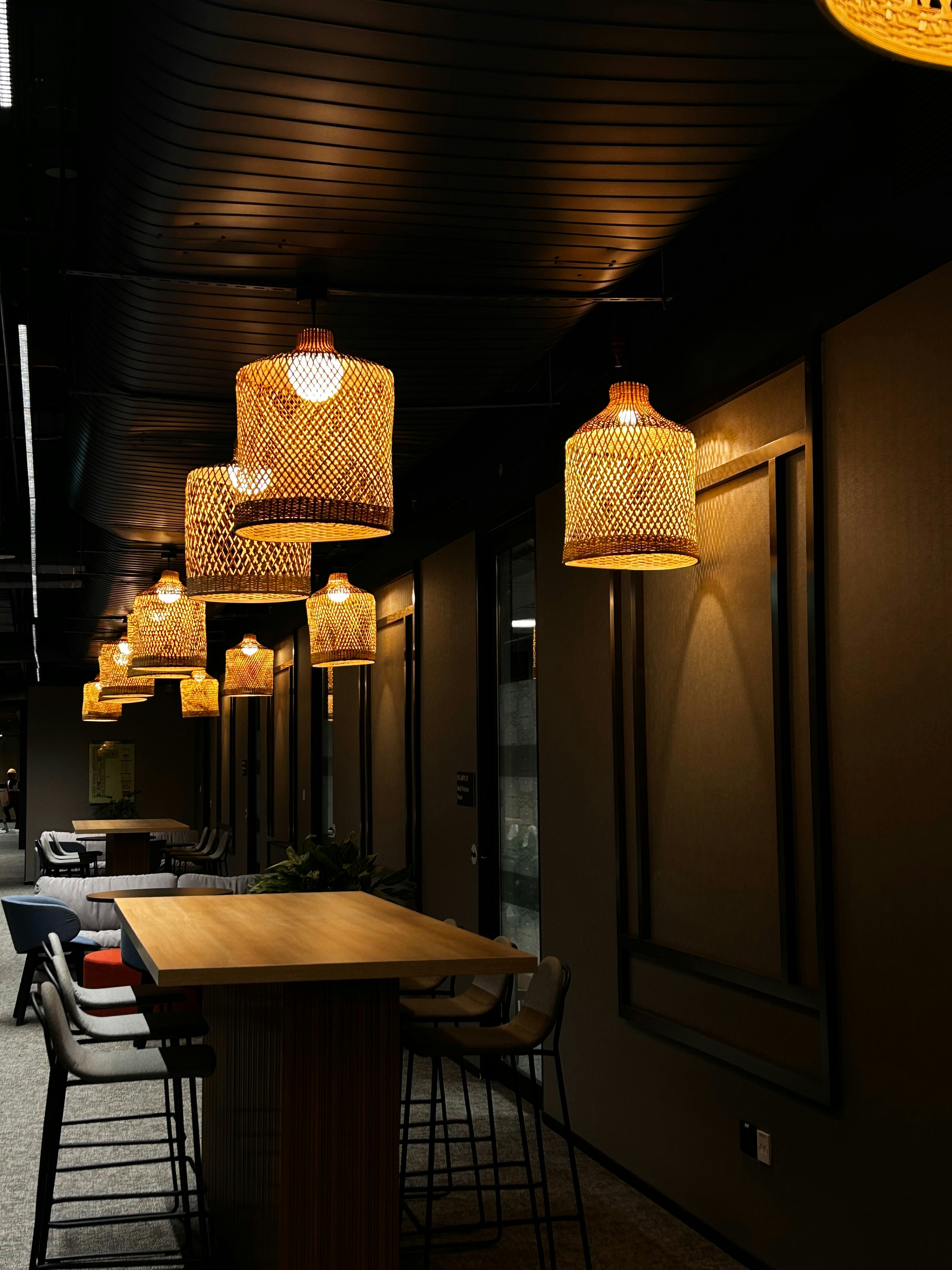 Restaurant interior showing industrial chic design with hanging lights and wooden tables