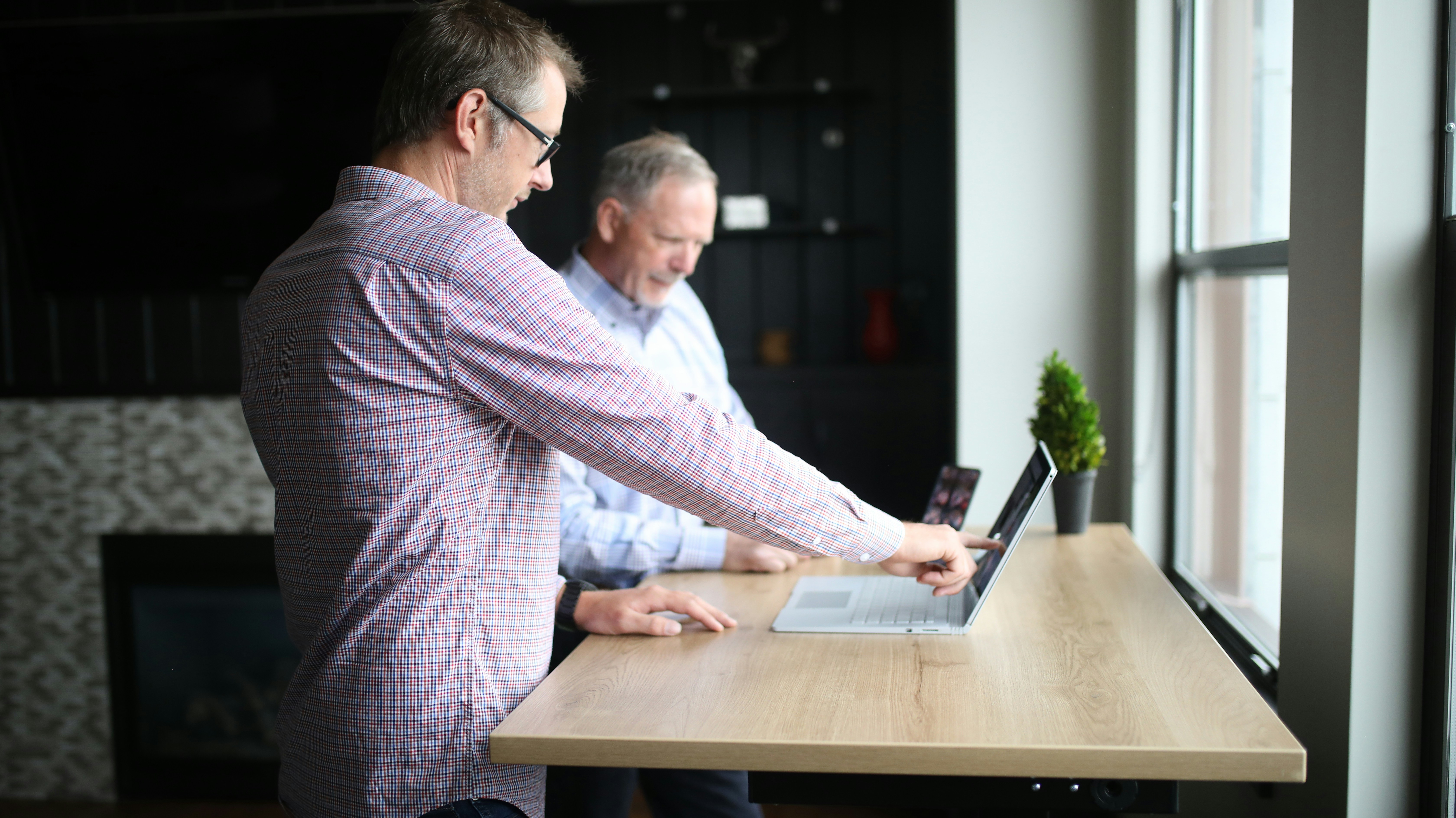 Two business partners looking at analytics on a tablet device in an office