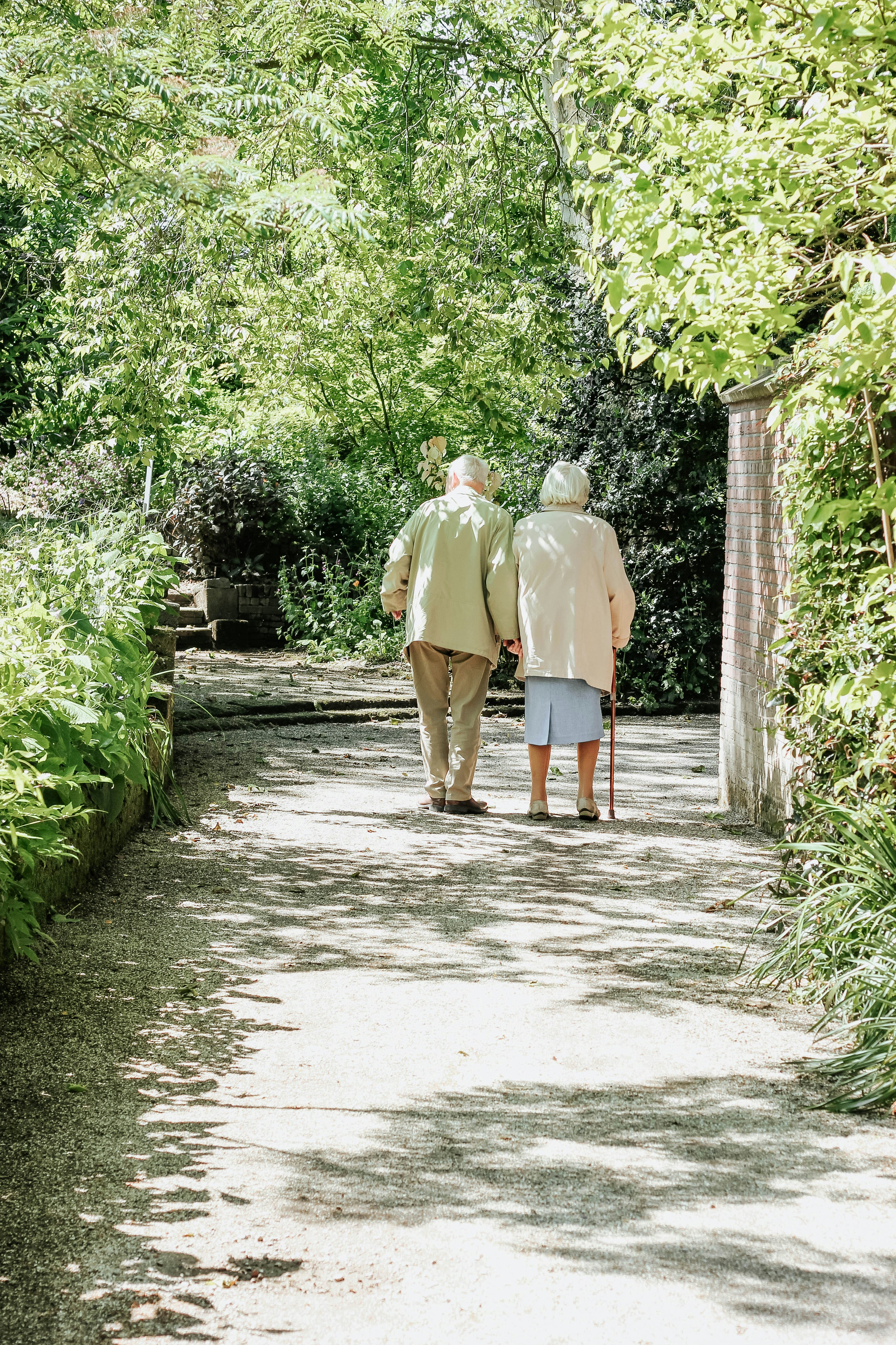 Un couple se promène main dans la main dans le Parc La Grange au milieu des rosiers en fleurs.
