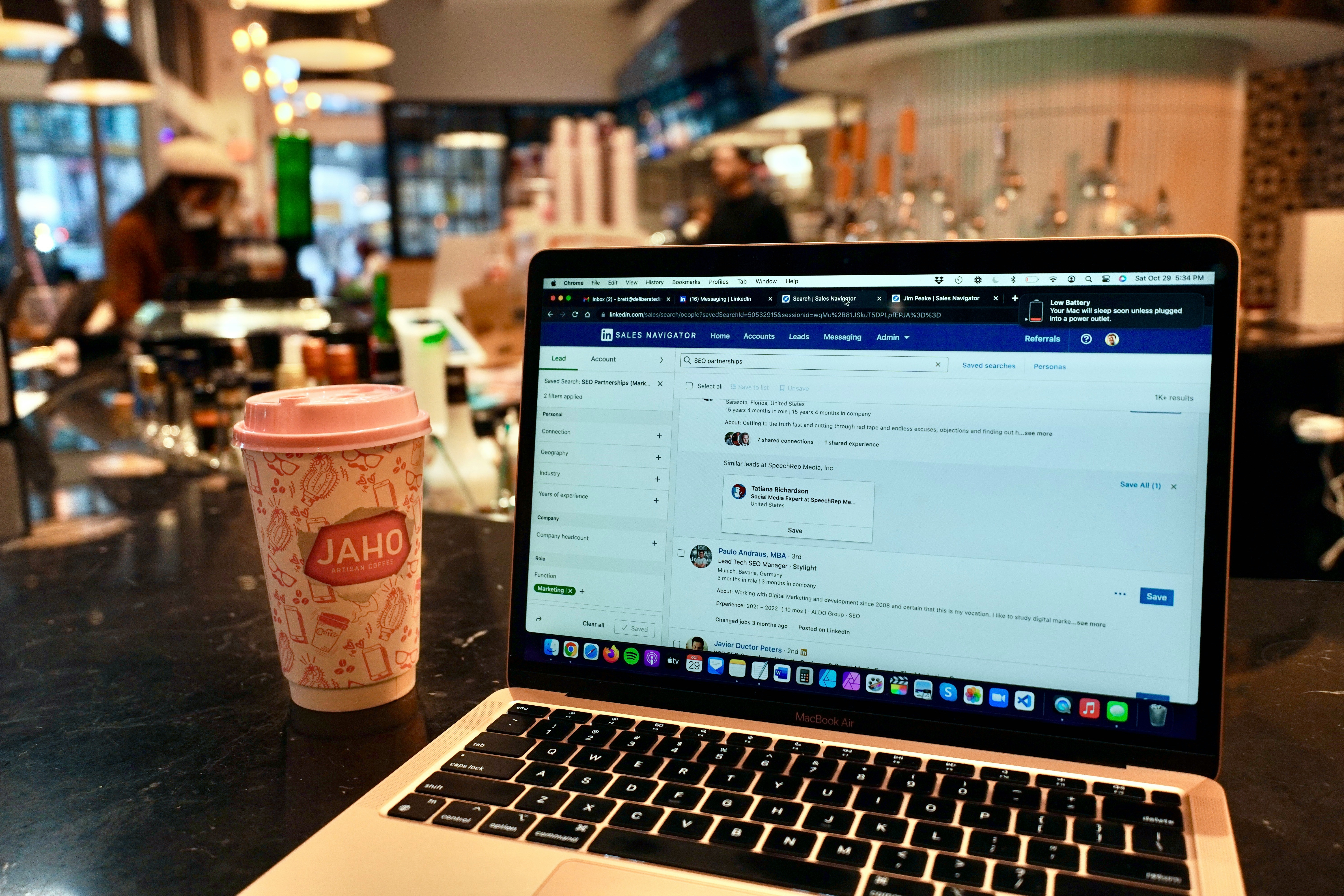 A shot of someone casually working on their laptop in a coffee shop, showing how easy it can be to manage your business with the right automation tools.