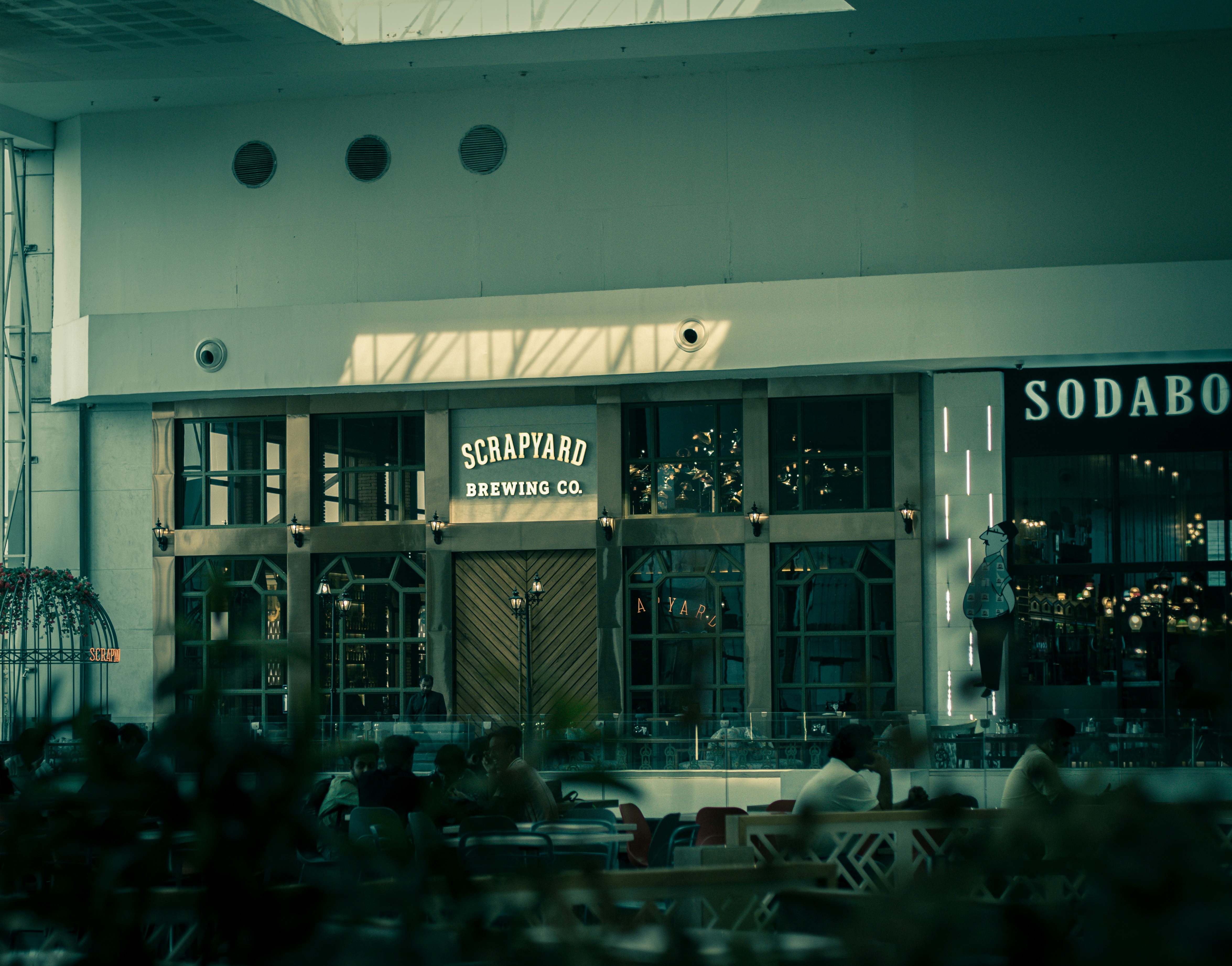 Close up of a camera lense focusing on a blurry background of a shopping mall