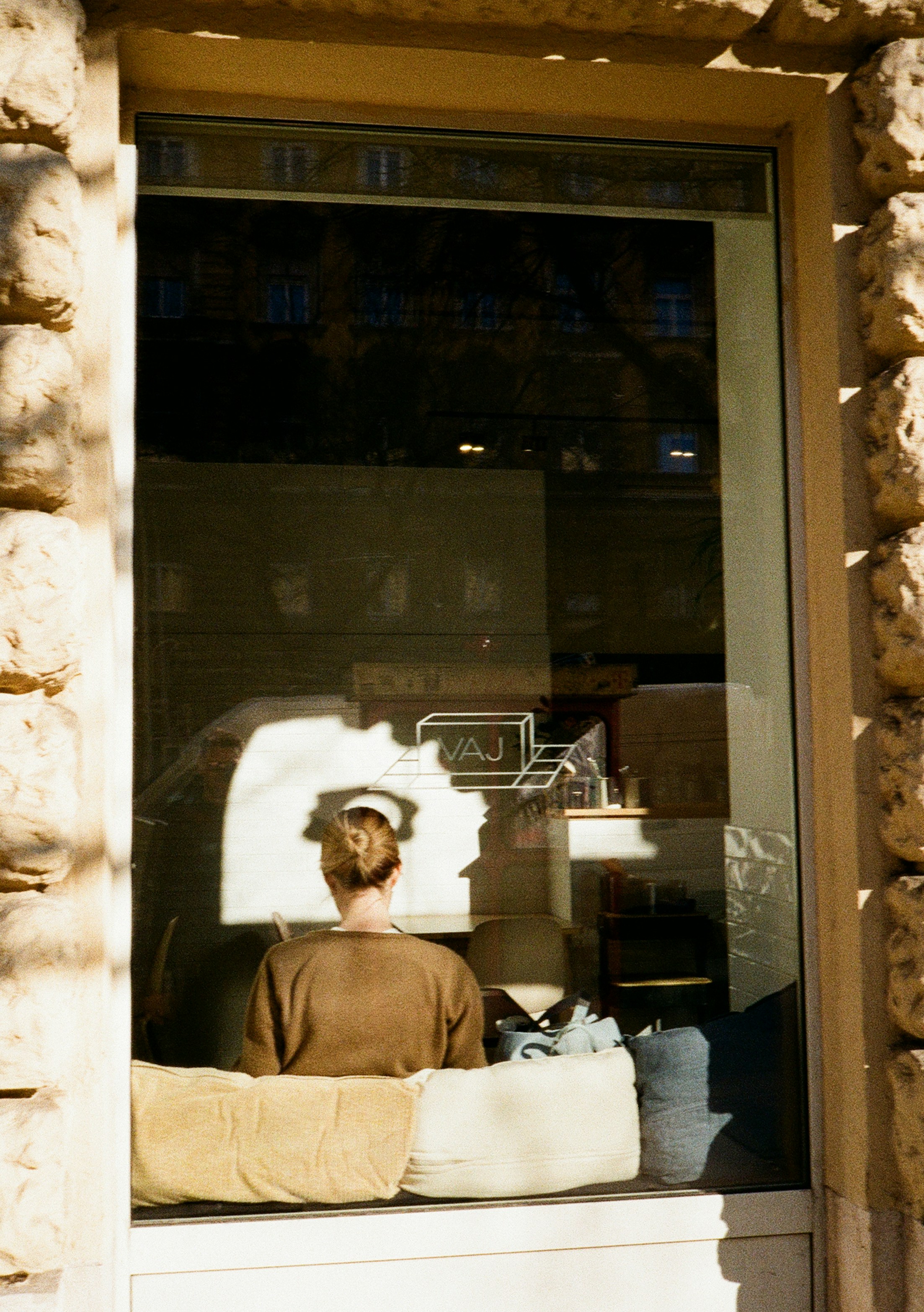 Close-up shot of a photographer's hand adjusting a camera lens focused on a bright shop window display