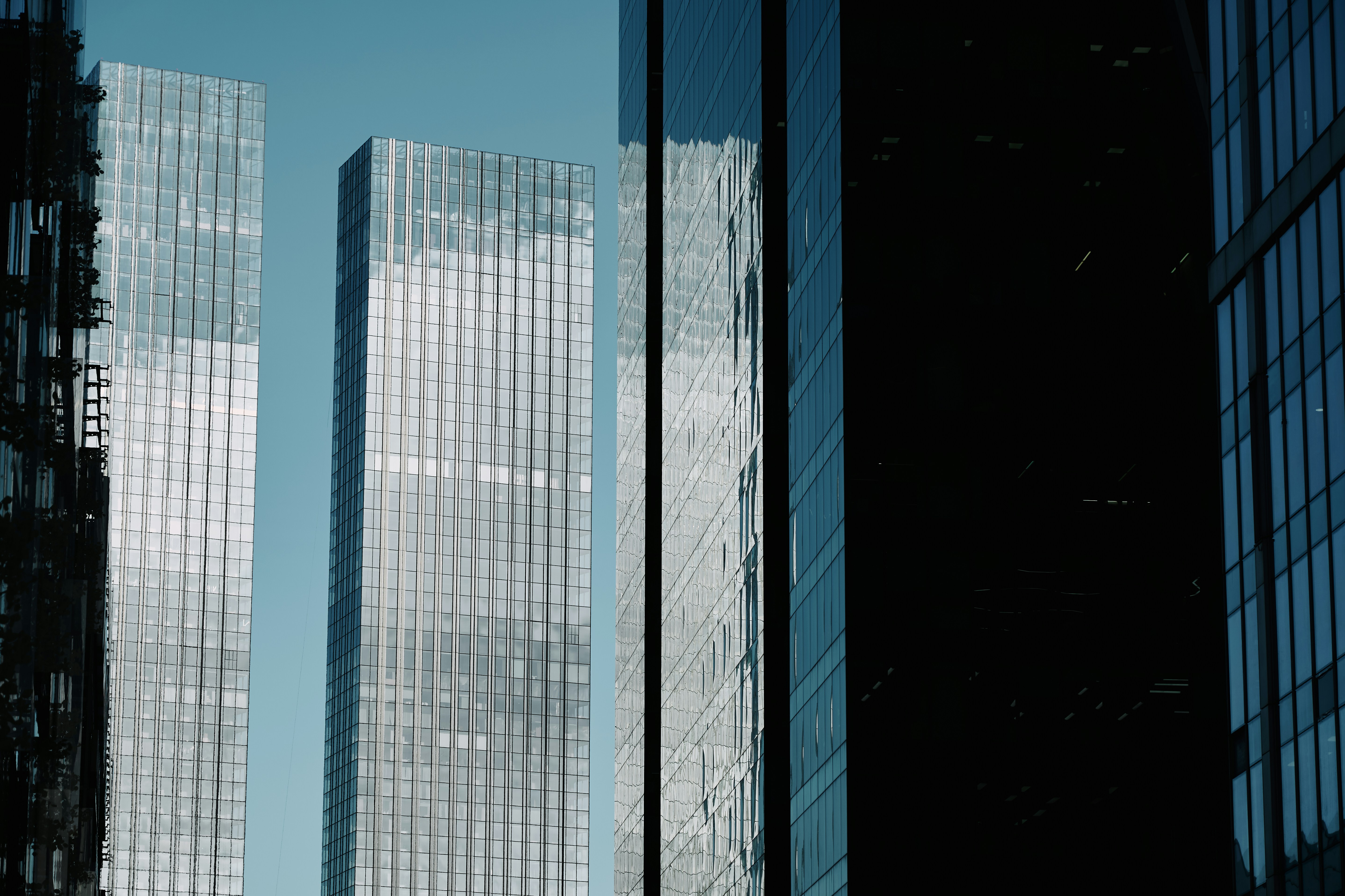 Hand holding a pen pointing at a printed graph showing three different financial projection lines