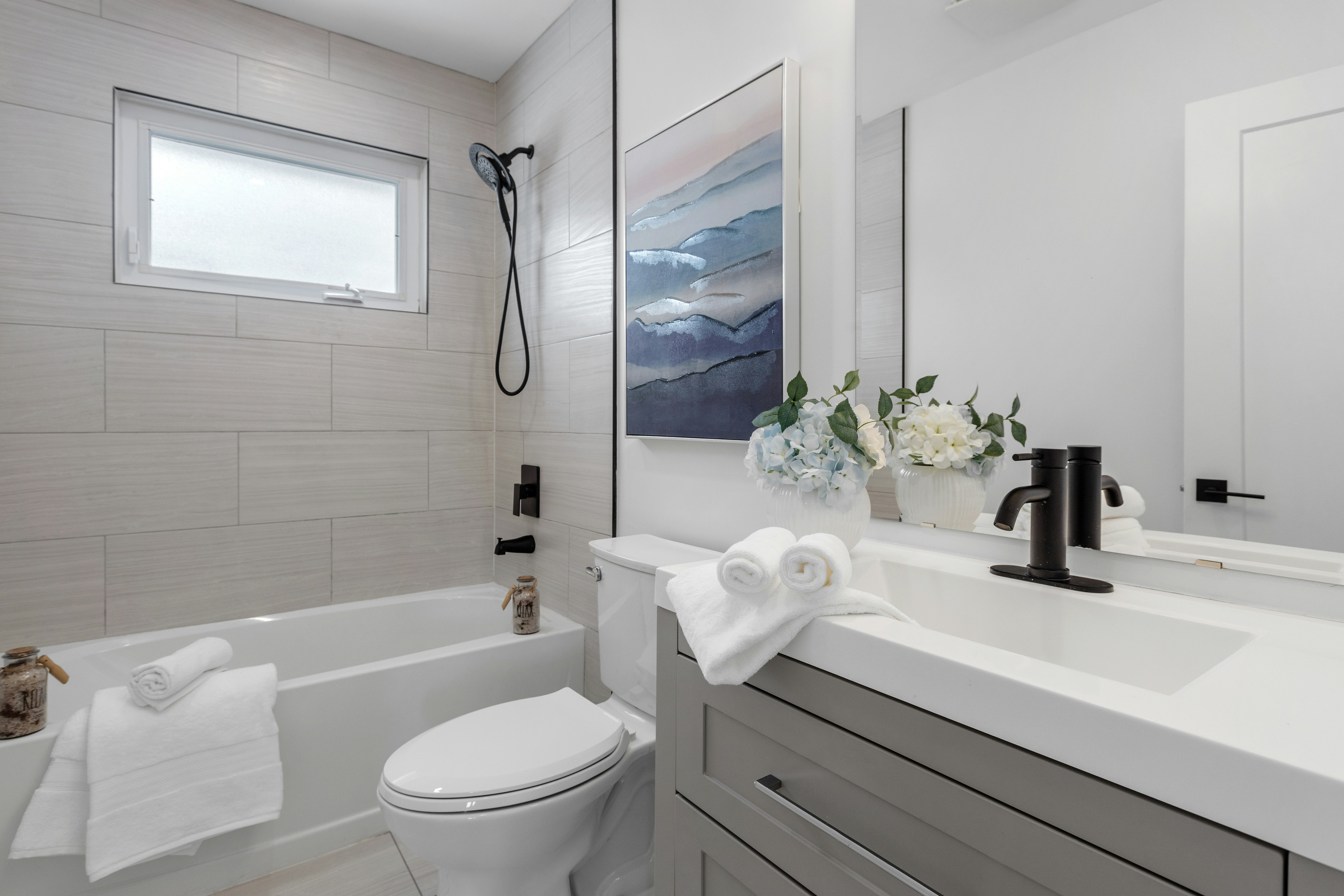 Intérieur de salle de bain blanche épurée, conçue pour la durabilité dans un bien locatif.