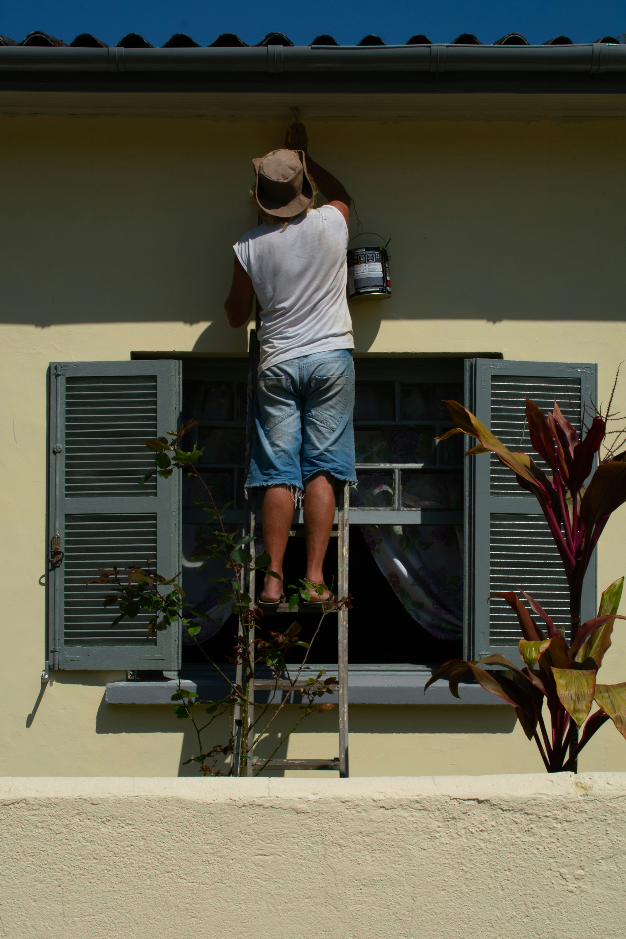 Worker carefully measuring a difficult window frame with insulation layer for insect screen installation