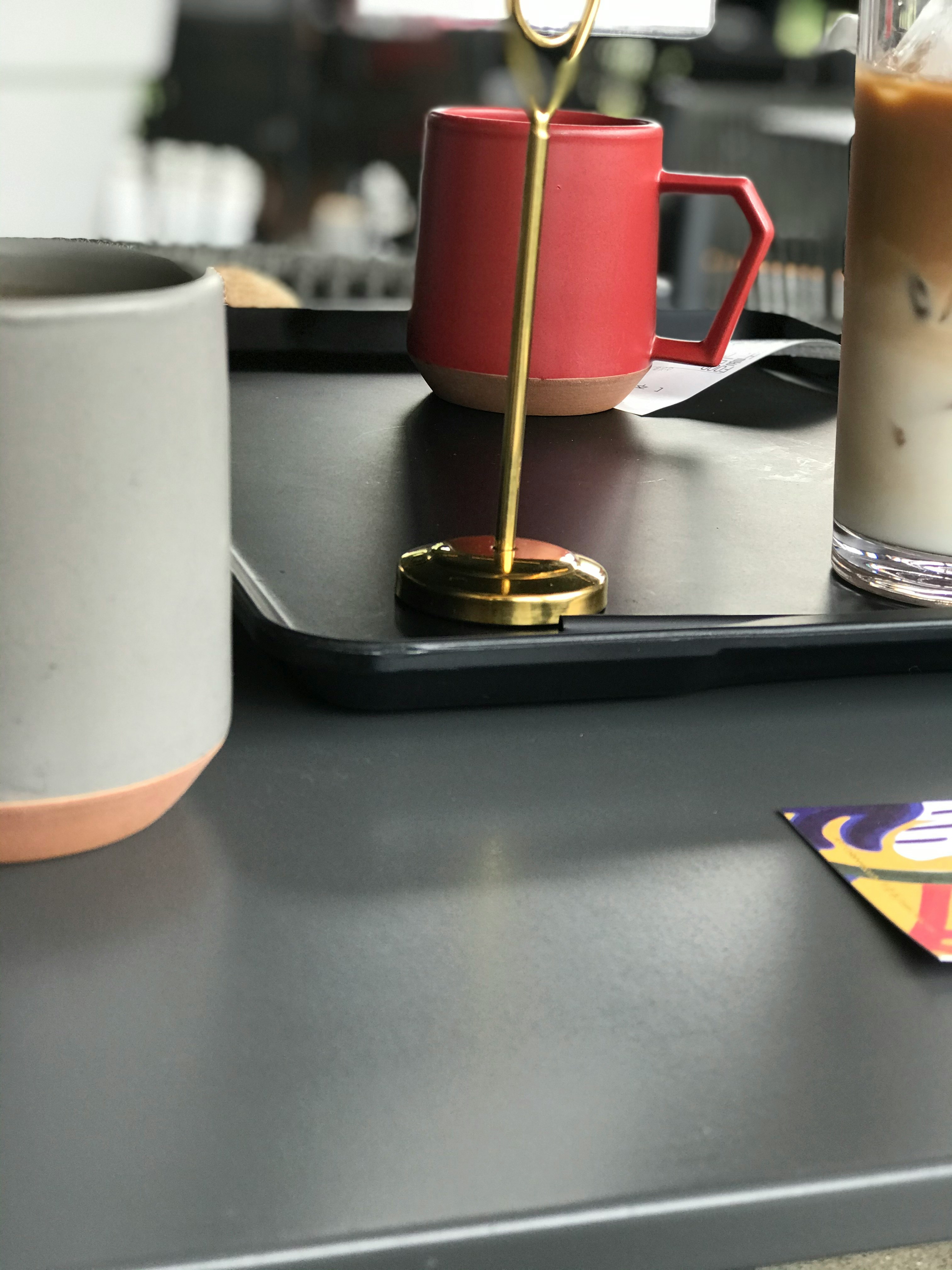 Overhead view of a messy architect desk with sketches, color samples, coffee cup and material swatches