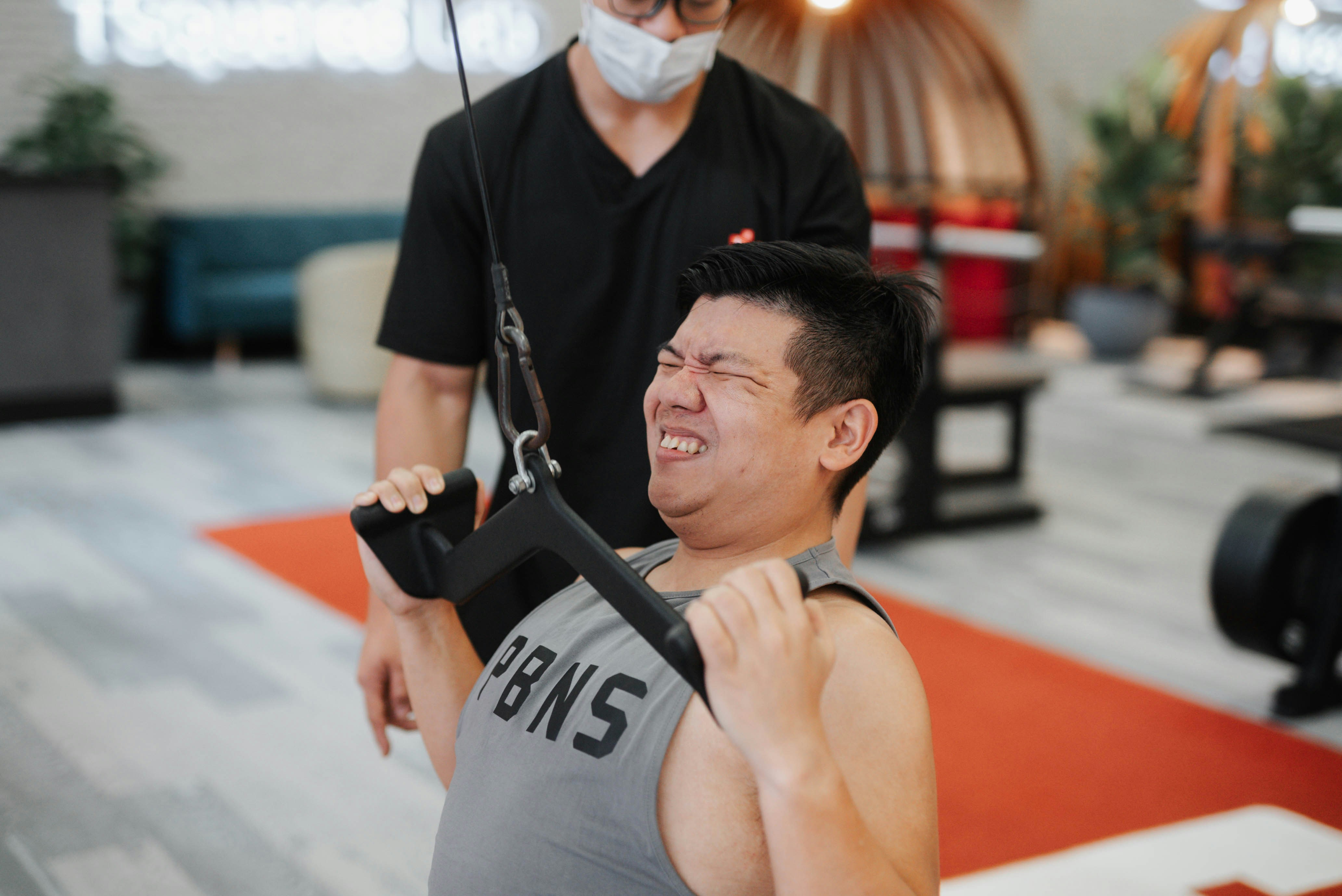Close up of a personal trainer adjusting weights for a client in a private gym setting