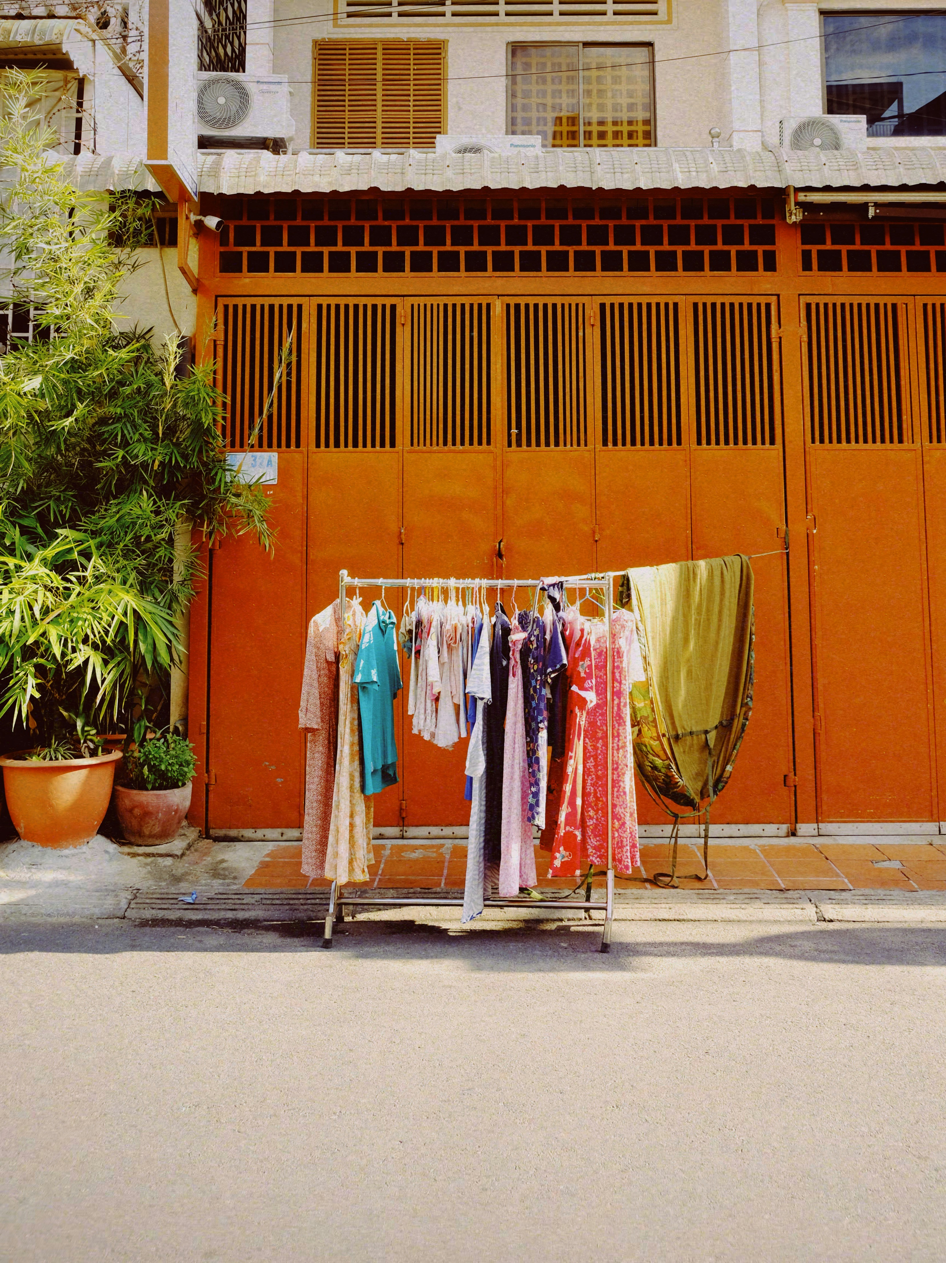 Penderie bien organisée dans une boutique montrant une gradation de couleurs de vêtements style californien